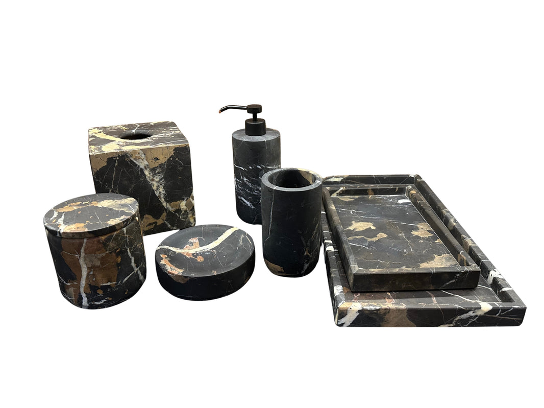 The Bathroom Set - Black Marble features trays, a soap dispenser, tumbler, tissue box cover, and storage containers with white and brown veining, elegantly displayed on a white background.