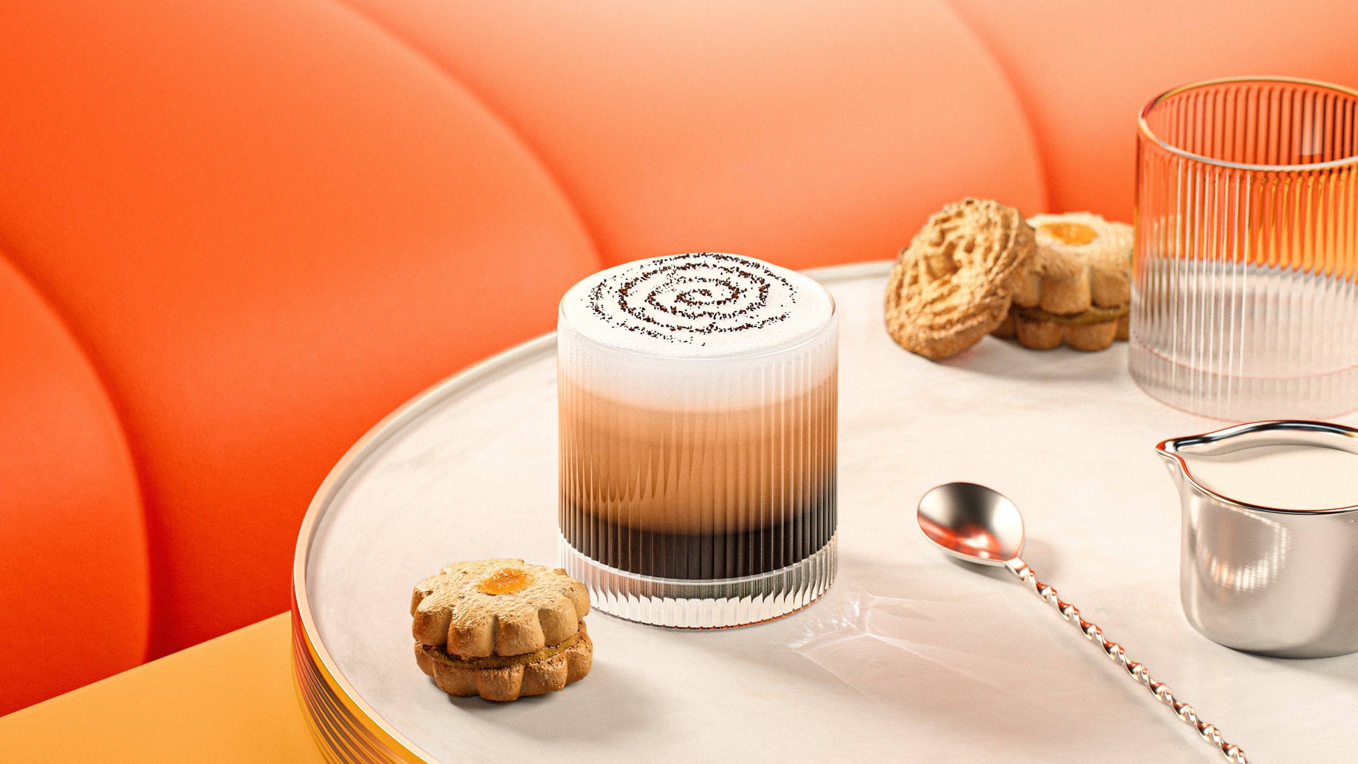 A Vintage Straight Line Tumbler - 10 oz is filled with layered iced coffee, topped with foam and cocoa powder, served on a round white tray with cookies, a silver spoon, water, and cream against an orange cushioned background.
