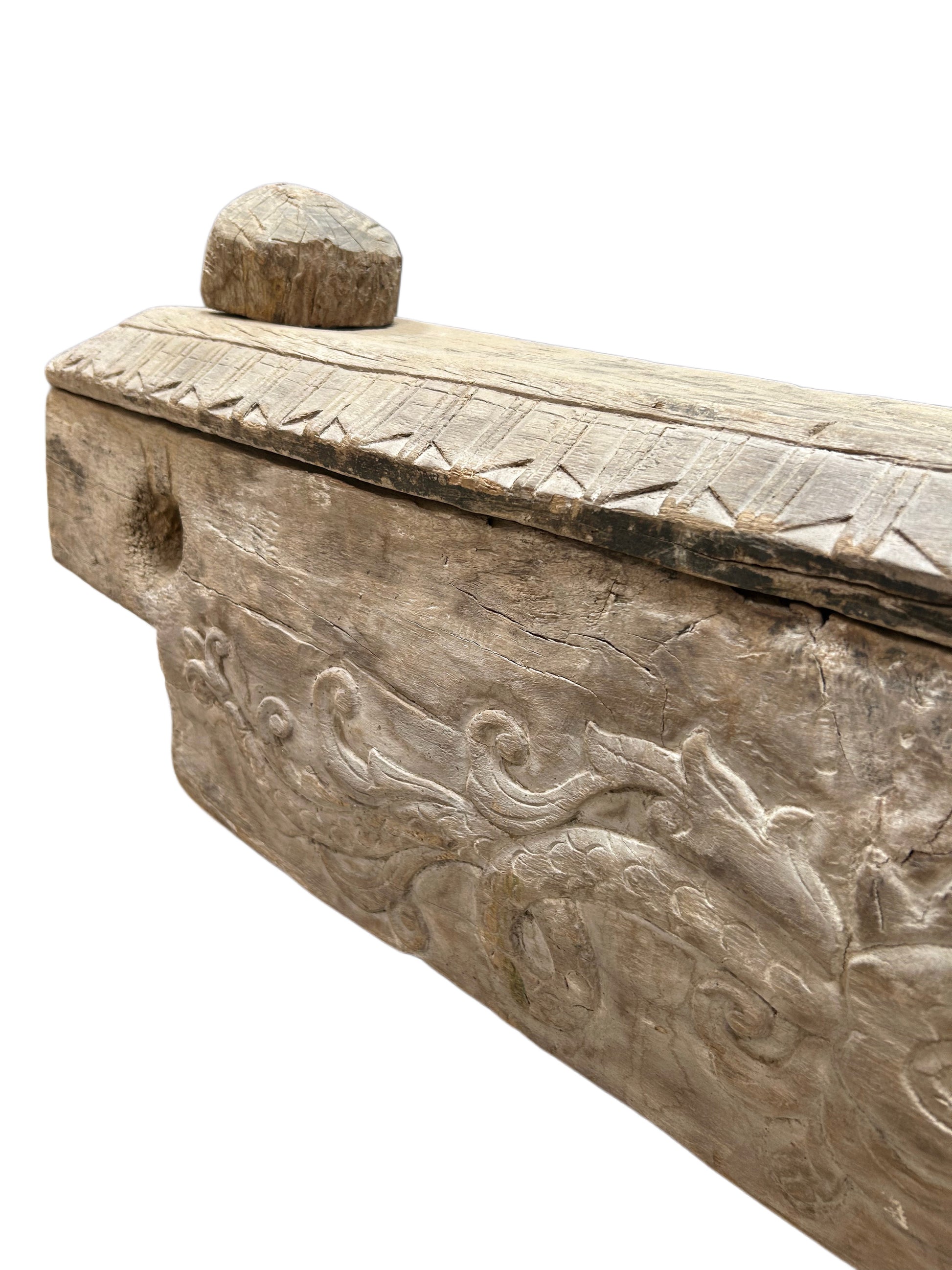 A close-up of a 19th-century Antique Wooden Dowry Chest highlights its intricate floral and geometric carvings, rounded top knob, and textured, weathered wood surface.