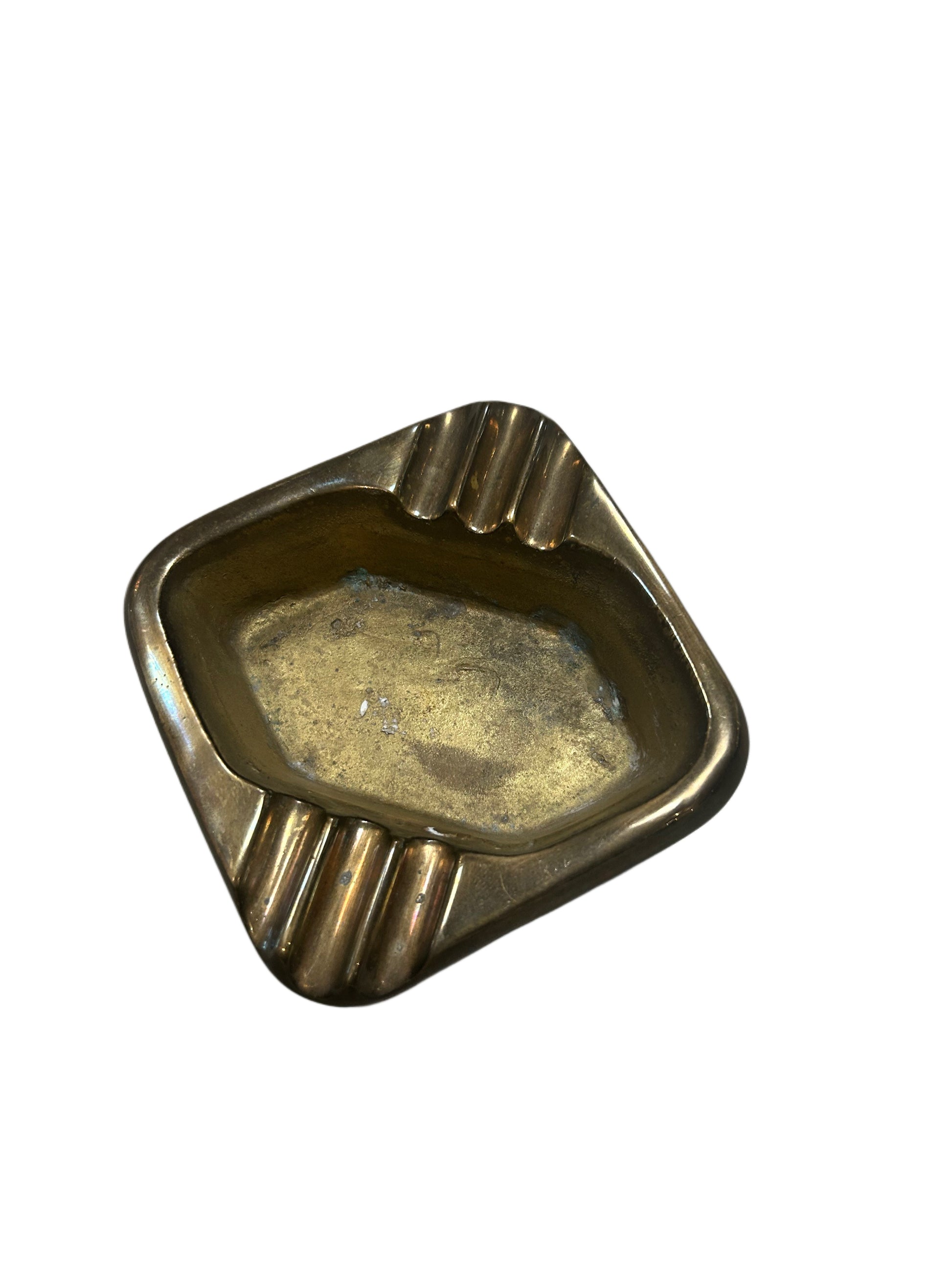 The Vintage Brass Ashtray has a rectangular shape with rounded edges and three grooved rests on one side, displayed on a white background.
