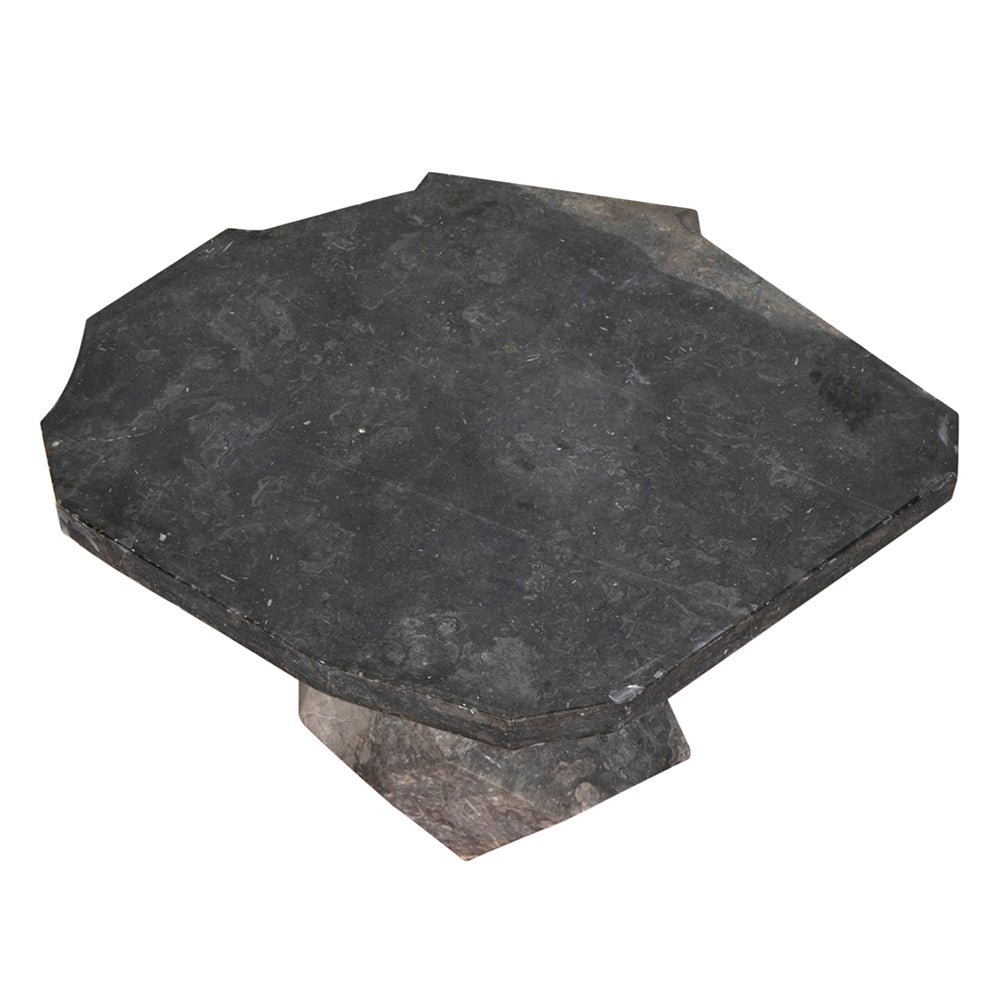The Rind Table in black marble features a dark, hexagonal stone slab with beveled edges atop a matching geometric base, adding stylish decor to any space.