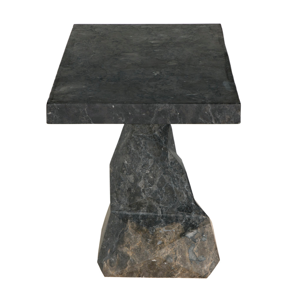 The Tilden Console in black marble features a square, thick top and an irregular geometric pedestal base, creating a modern entryway table. Shown against a white background.