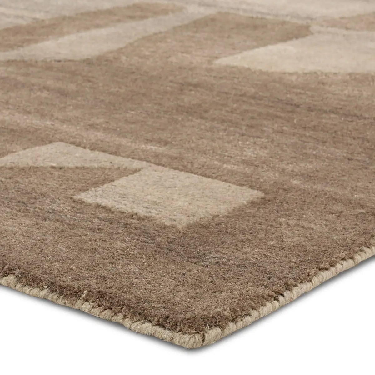 A close-up of the Abstract Forms Rug - Light Brown/Camel displays its soft, hand-tufted texture and subtle geometric pattern, highlighted against a white background with neatly finished edges.