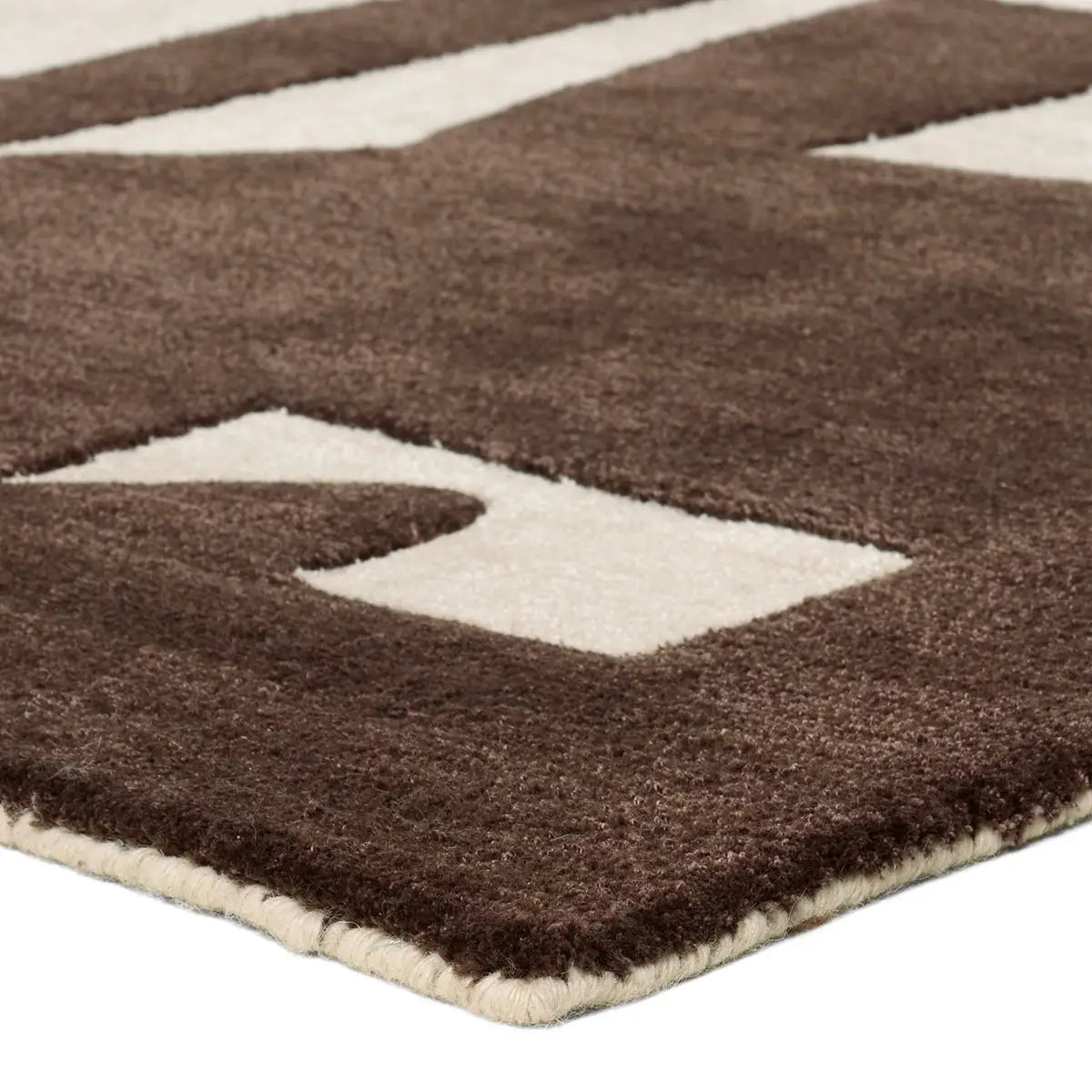 The Abstract Forms Rug - Brown/Ivory features a thick, hand-tufted wool-viscose blend with a brown and ivory geometric pattern, plush texture, and neatly finished edges.