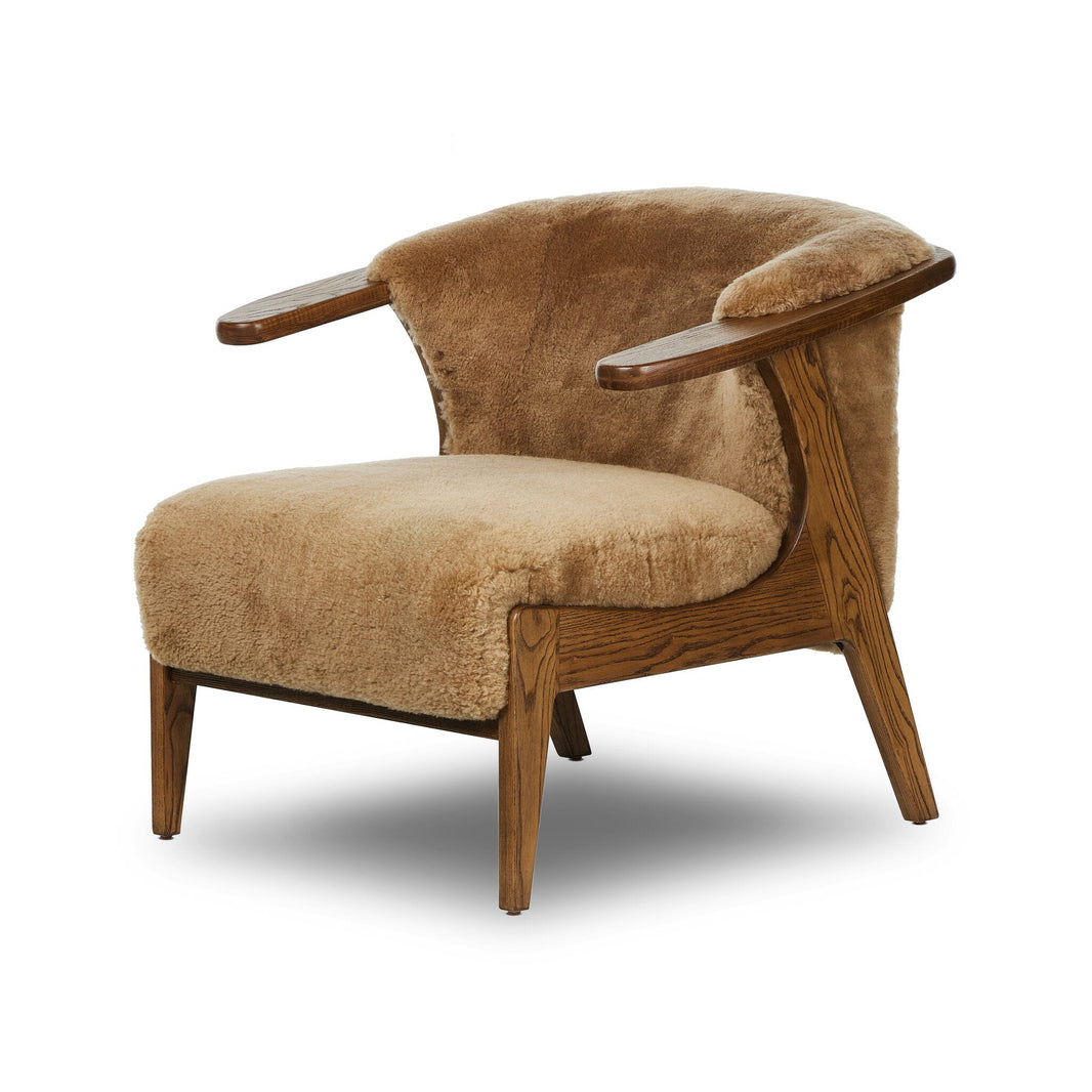 The Fabian Chair features plush tan upholstery, wooden legs and armrests, and a smoothly curved backrest. Its compact size and cozy design make this modern chair an inviting addition to any room.