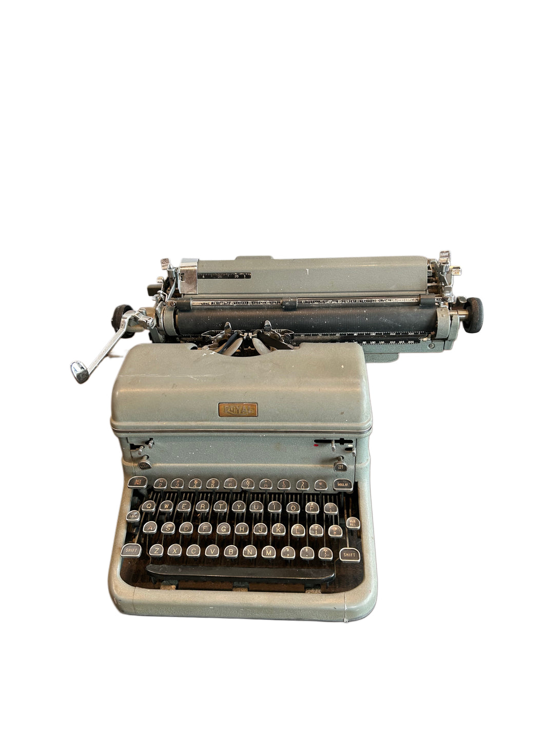 A vintage Royal typewriter with round black keys sits on a white background. The brand name “Royal” appears above the keyboard.