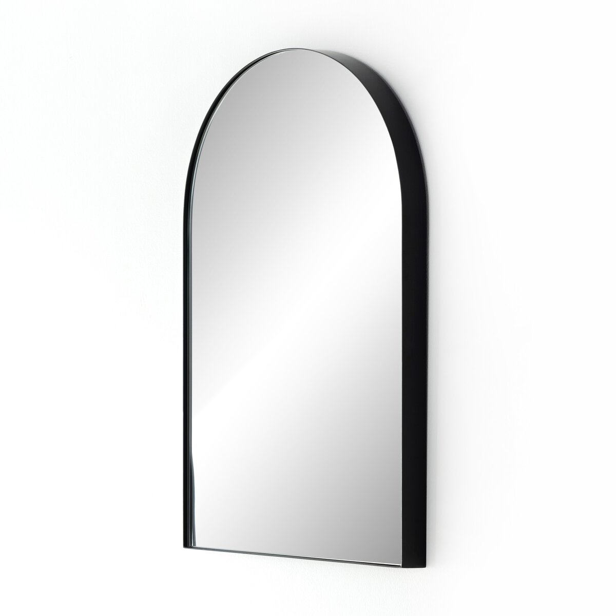 The Georgina Small Mirror is a wall-mounted, 21x32 inch mirror with a black frame, rounded arch top, and flat bottom. This elegant piece reflects light beautifully on a plain white background.