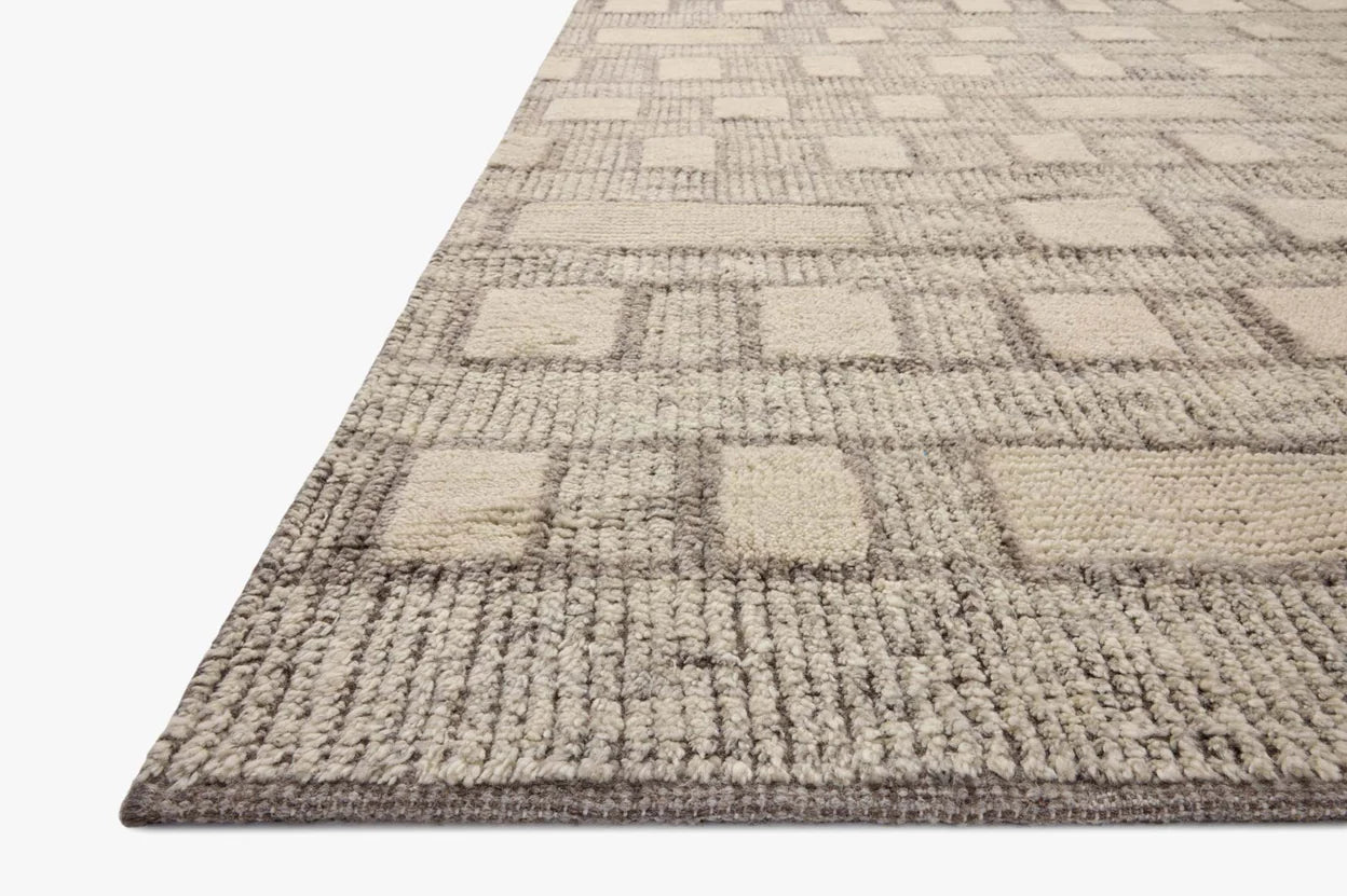 Close-up of the Indian Wool Tribal Rug (8'6" x 11'6"), a 100% wool rug with a textured geometric pattern of raised rectangles and squares in beige and light brown. Displayed on white; available in multiple sizes.