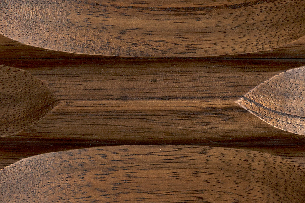 Close-up of the Malic shelf in dark walnut, showcasing its smooth, polished wooden surface with carved curves and natural grain—ideal for adding character and functional storage to any room.