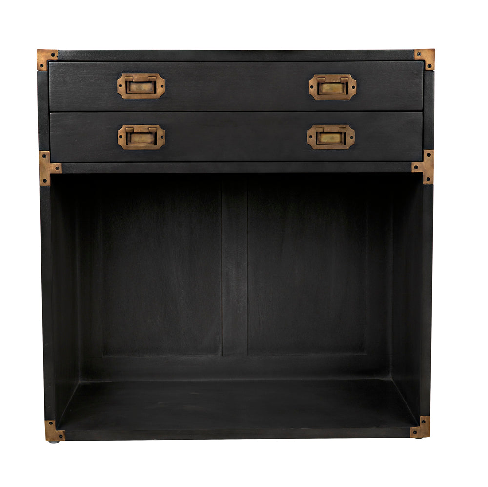 The Campaign Chest, Pale is a black wooden side table with two top drawers featuring brass handles and corners, plus an open rectangular storage space below.