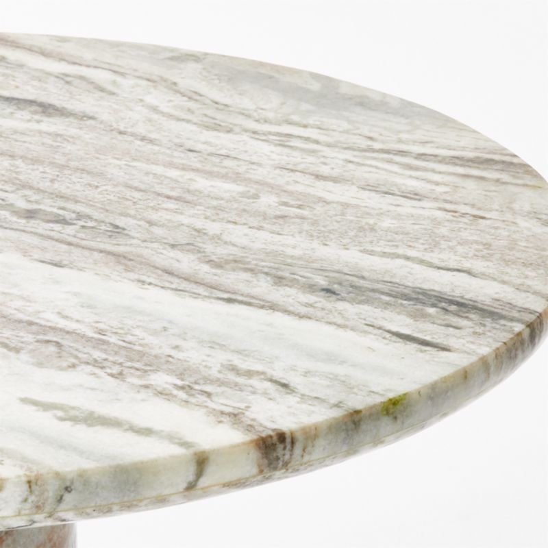 A close-up of the Grey Marble Bistro Table, a 30-inch round table showcasing a marble tabletop with grey, white, and light brown veining on its smooth surface. The table’s edge is slightly visible against a white background.