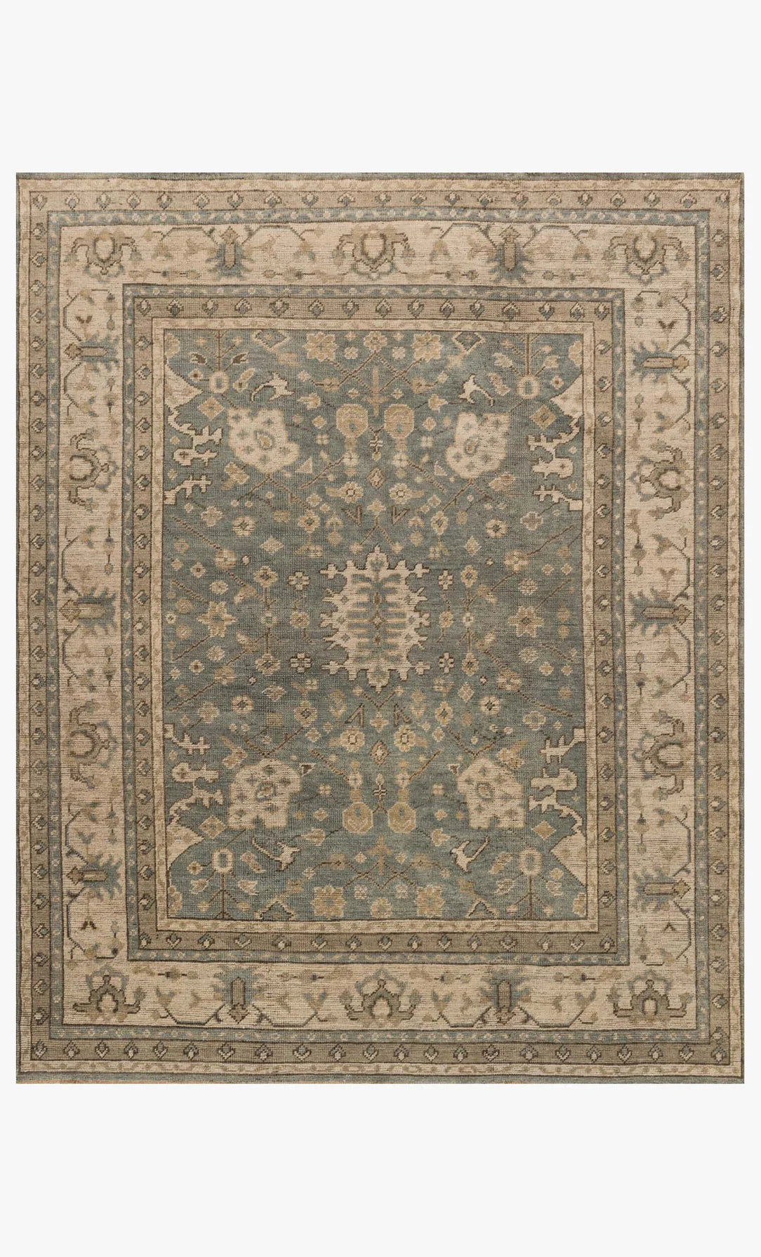 The Heirloom Rug Collection 8 x 10 is hand-knotted from premium wool, showcasing an ornate floral and geometric design in muted blue, beige, and taupe with a detailed border and central medallion for a traditional vintage appeal.