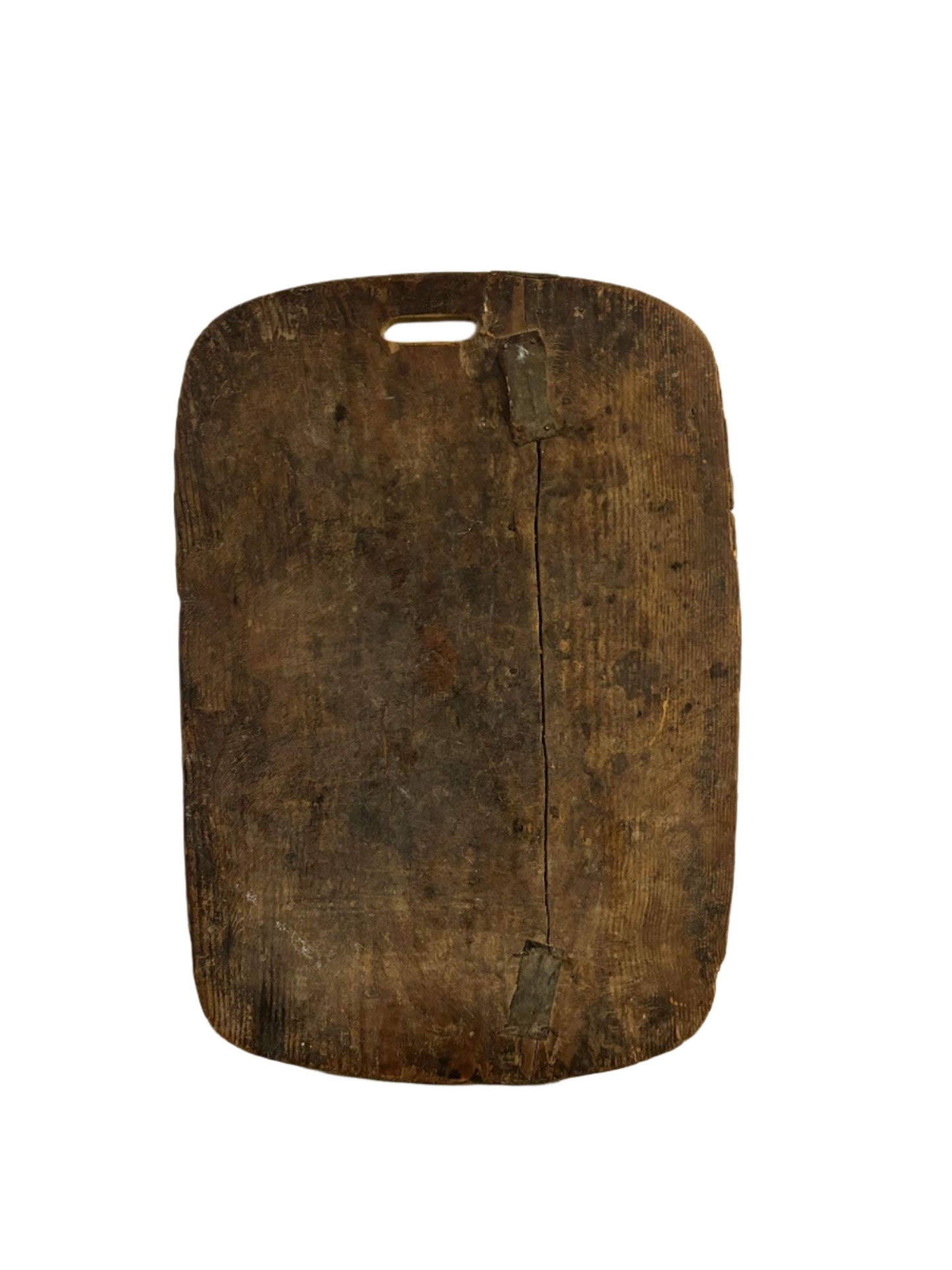 The Handle Wood Cutting Board, rectangular with a handle slot and secured by two metal braces over a visible vertical crack, rests on a small desk against a white background.