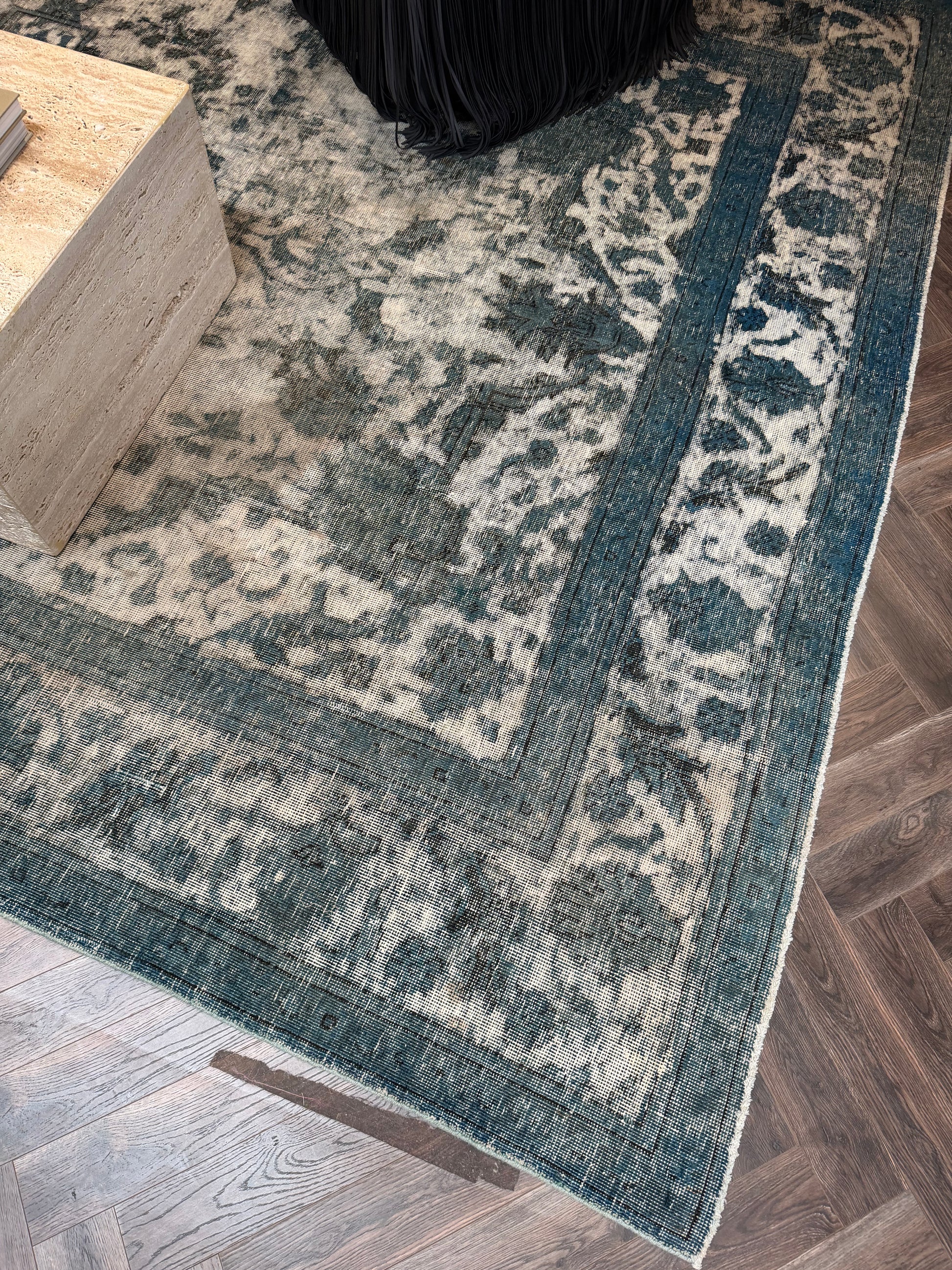 Vintage Blue Distressed Wool Area Rug in blue and cream on a dark wooden floor inside an 8x12 shed.