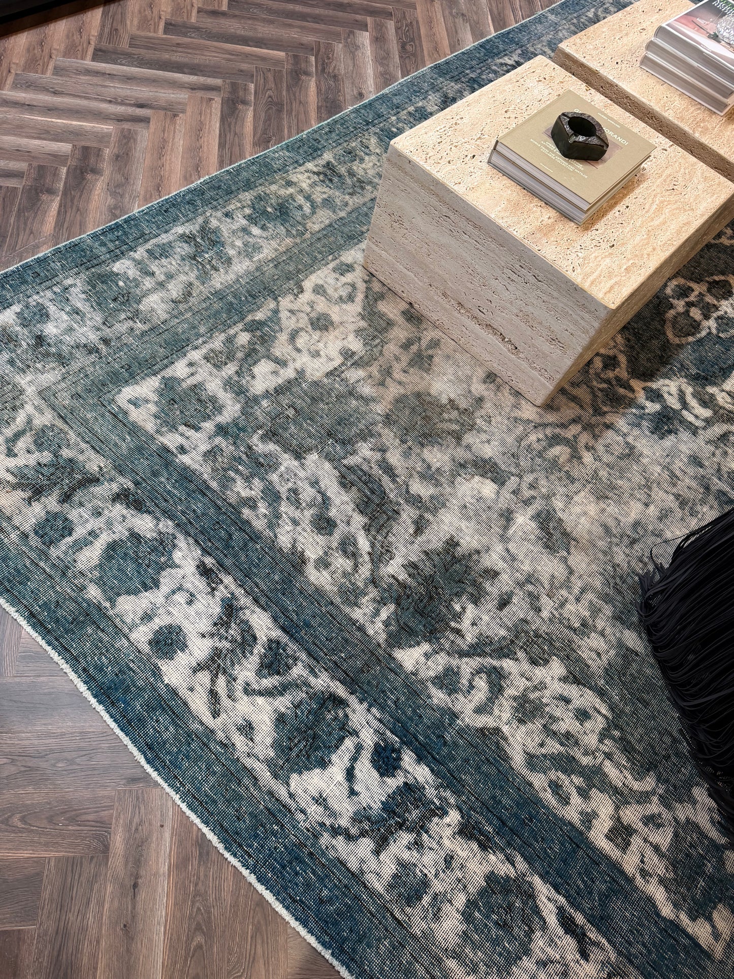 Vintage Blue Distressed Wool Area Rug with a faded, ornate pattern, partially covered by a rectangular stone side table inside an 8x12 garden shed.