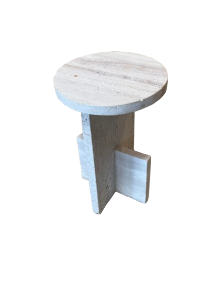 The Travertine Accent Table is a small, round, light-colored wooden side table with intersecting vertical and horizontal supports, featuring a vintage travertine-inspired style and shown on a white background.