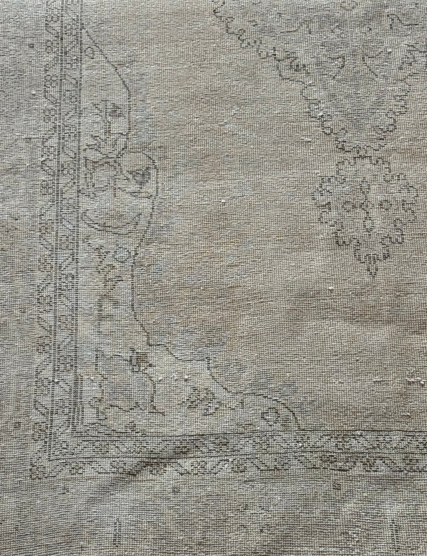 7' x 11' Dark Beige Vintage Rug featuring a faded, vintage look with a dark beige background and subtle, worn-out floral and geometric border patterns in soft gray tones—an ideal statement piece for spacious interiors.