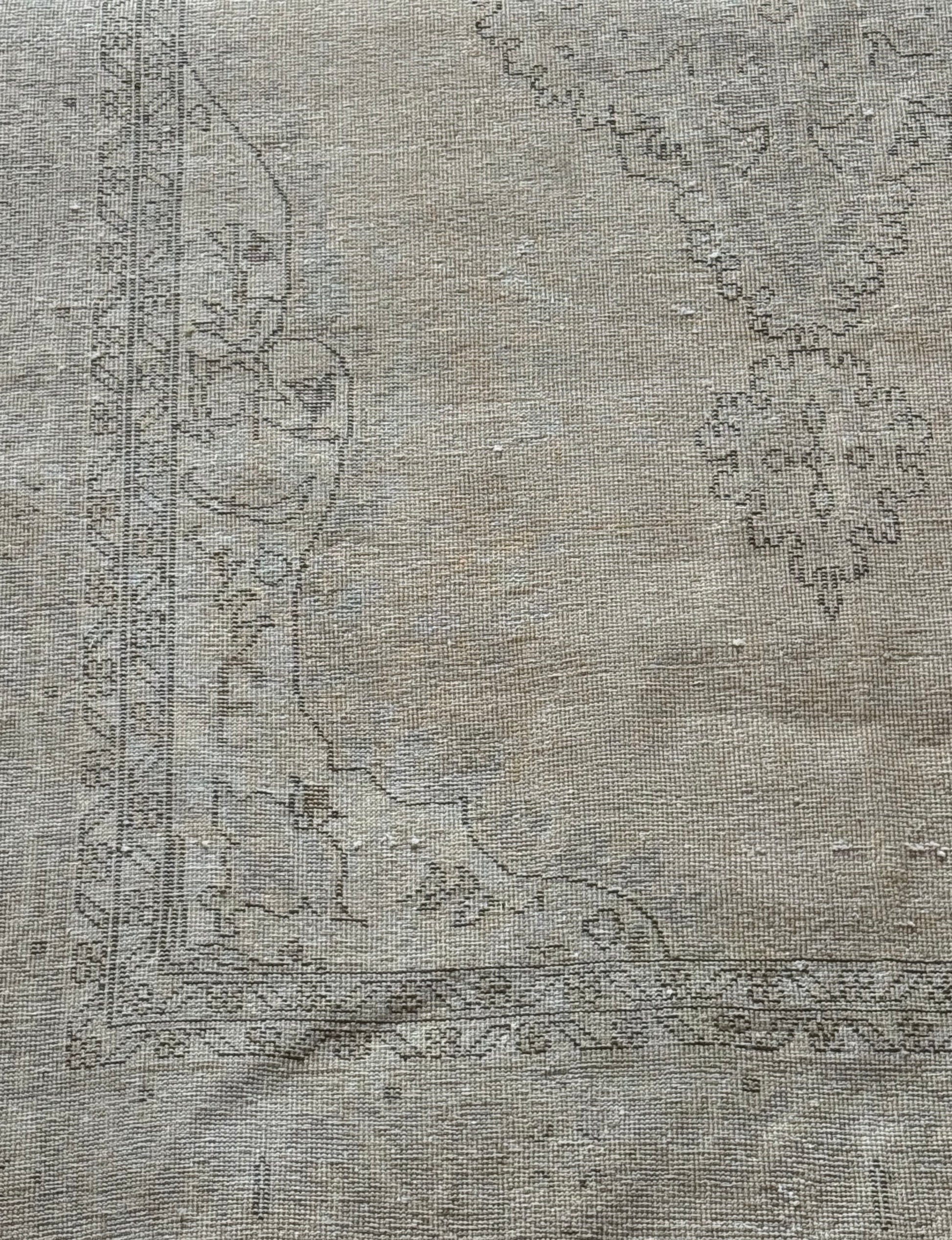 7' x 11' Dark Beige Vintage Rug featuring a faded, vintage look with a dark beige background and subtle, worn-out floral and geometric border patterns in soft gray tones—an ideal statement piece for spacious interiors.