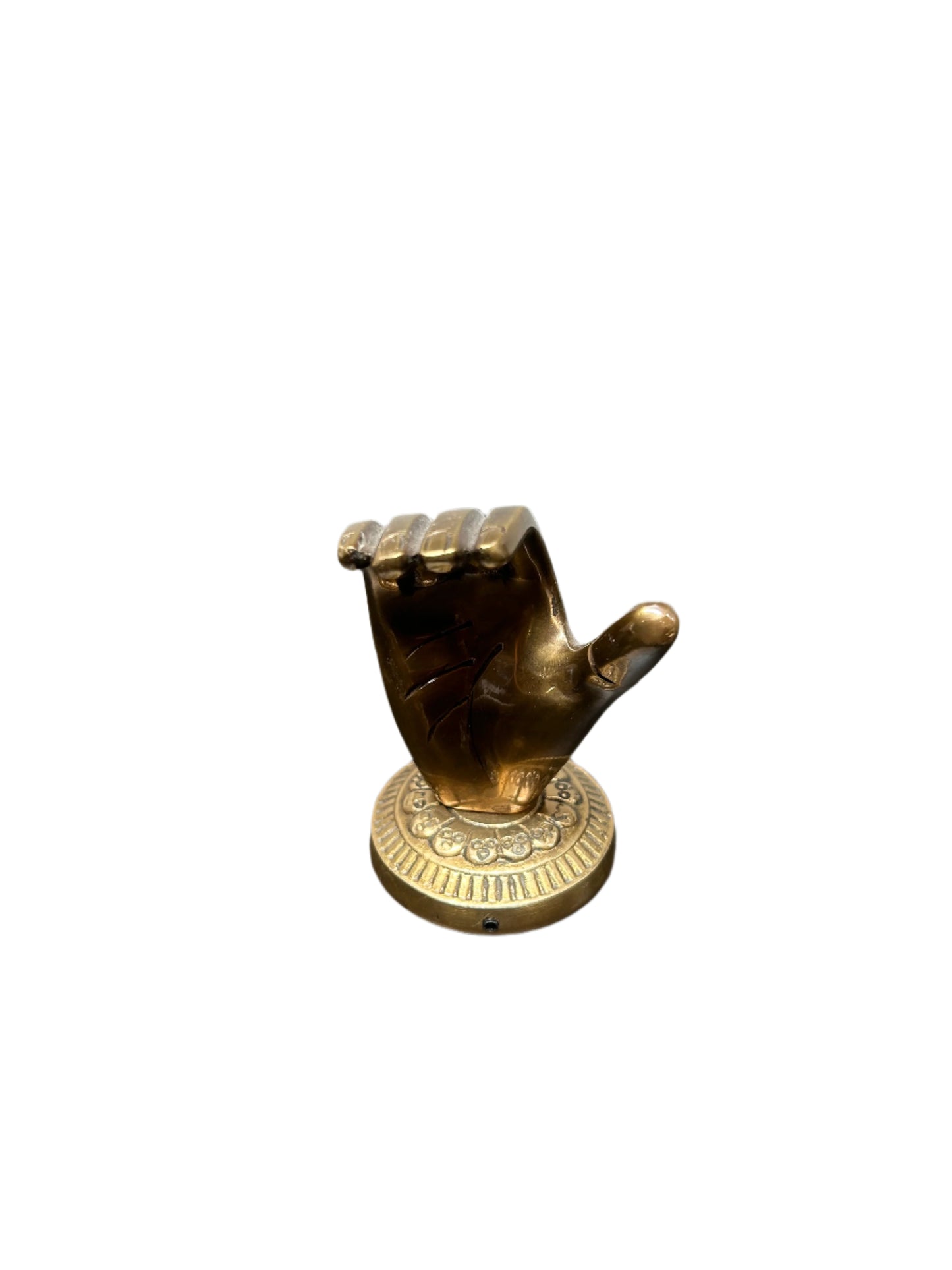 The Brass Hand Object is a small brass sculpture with fingers curled inward and thumb extended upward, mounted on a round decorative base. It measures 4"H x 2.5"W and is shown isolated on a white background.