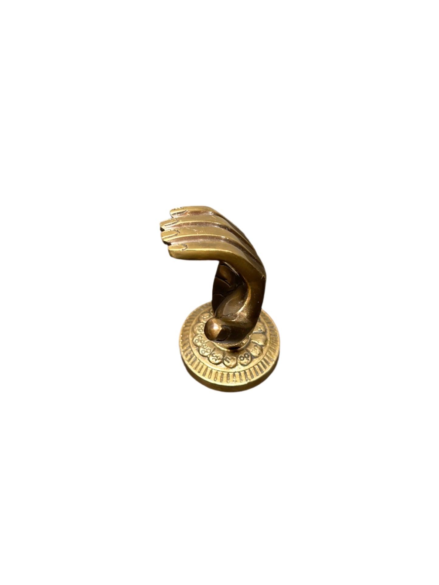 The Brass Hand Object is a small brass sculpture featuring an upright hand with slightly bent fingers and an extended thumb on a round base; measures 4"H x 2.5"W.
