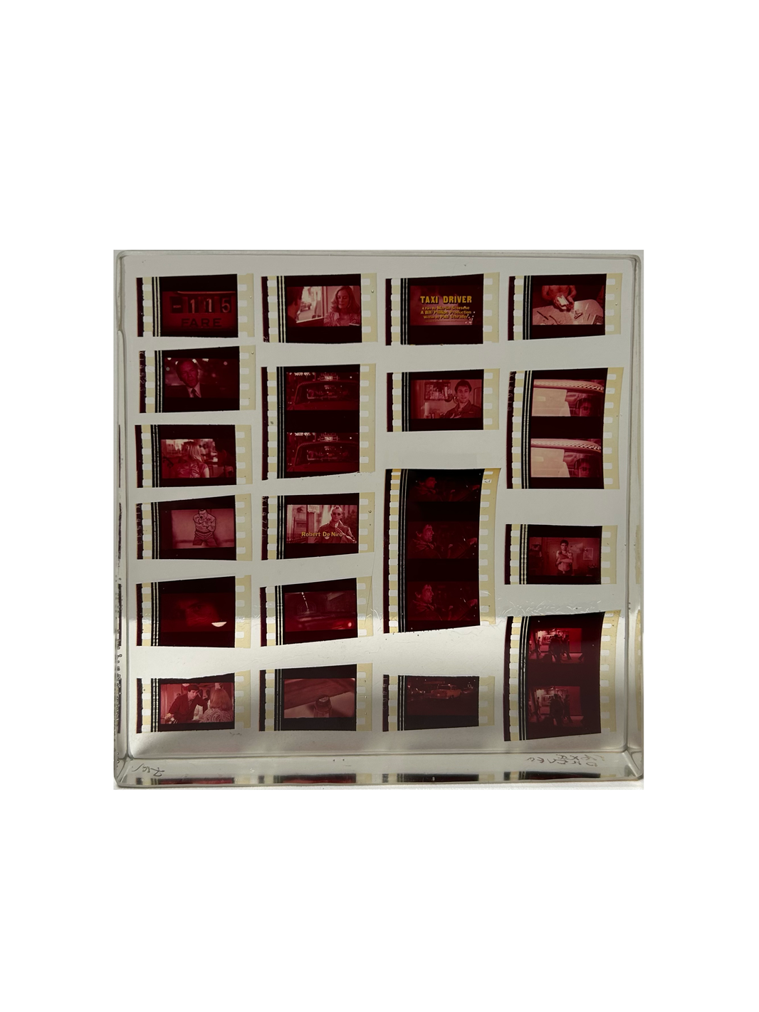 The Movie Reel in Acrylic features red-tinted film negatives with scenes from Taxi Driver, showcased as a unique collectible against a plain white background.