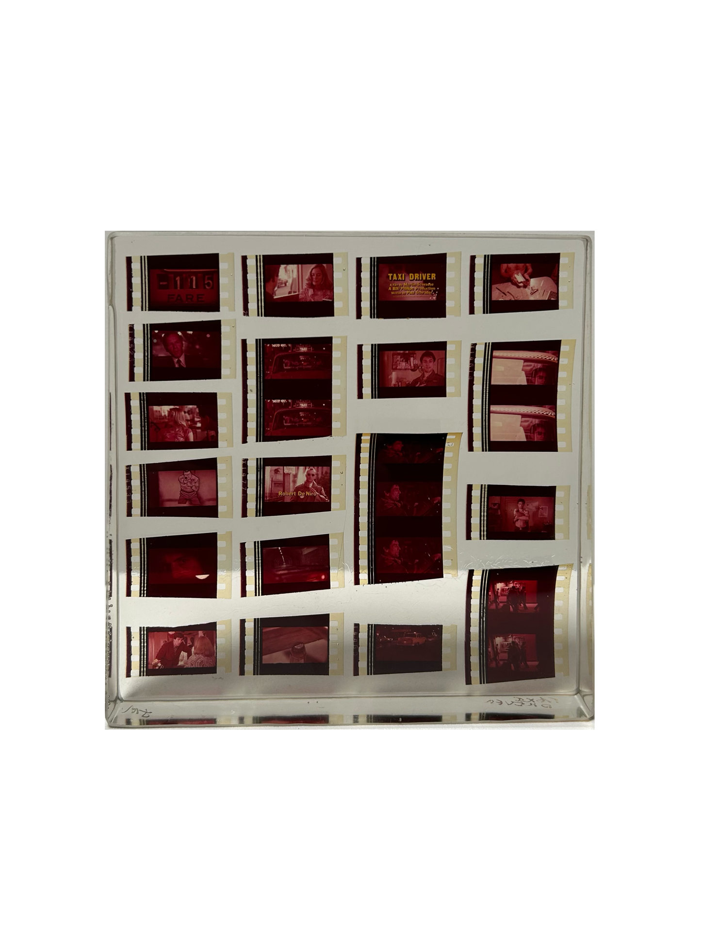 The Movie Reel in Acrylic features red-tinted film negatives with scenes from Taxi Driver, showcased as a unique collectible against a plain white background.