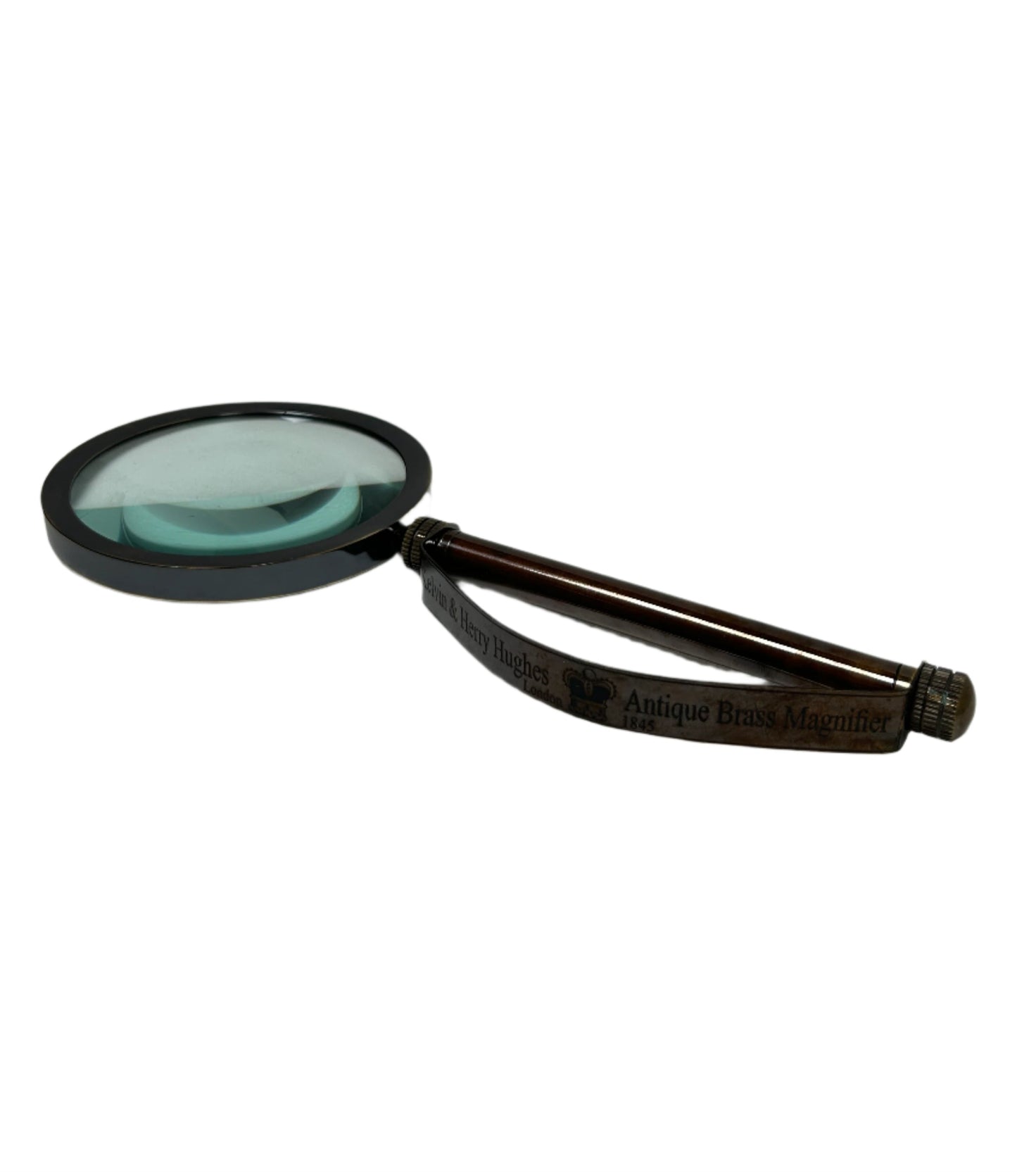 The Brass Strap Magnifying Glass, featuring a round optical lens and vintage brass strap details with a dark wooden handle, is displayed on a white background.