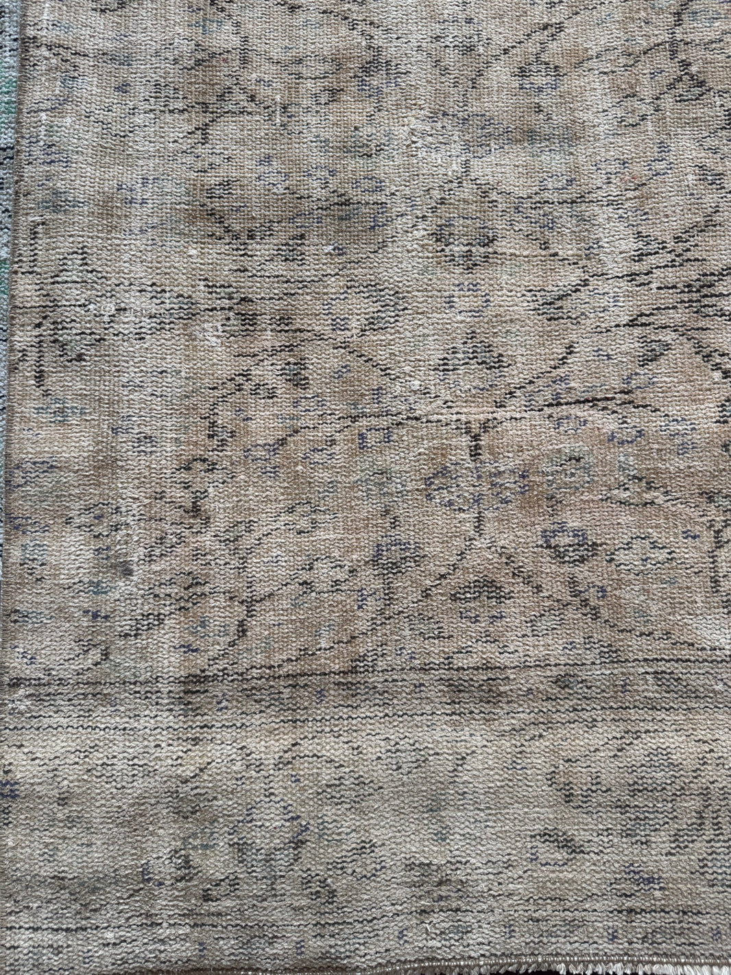 Vintage Turkish Runner Rug featuring a faded tan background with muted beige and light brown tones, subtle floral and geometric designs, and aged, worn details for a classic vintage look.