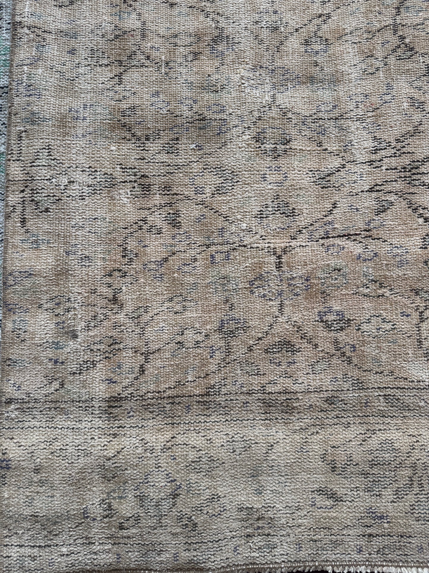 Vintage Turkish Runner Rug featuring a faded tan background with muted beige and light brown tones, subtle floral and geometric designs, and aged, worn details for a classic vintage look.
