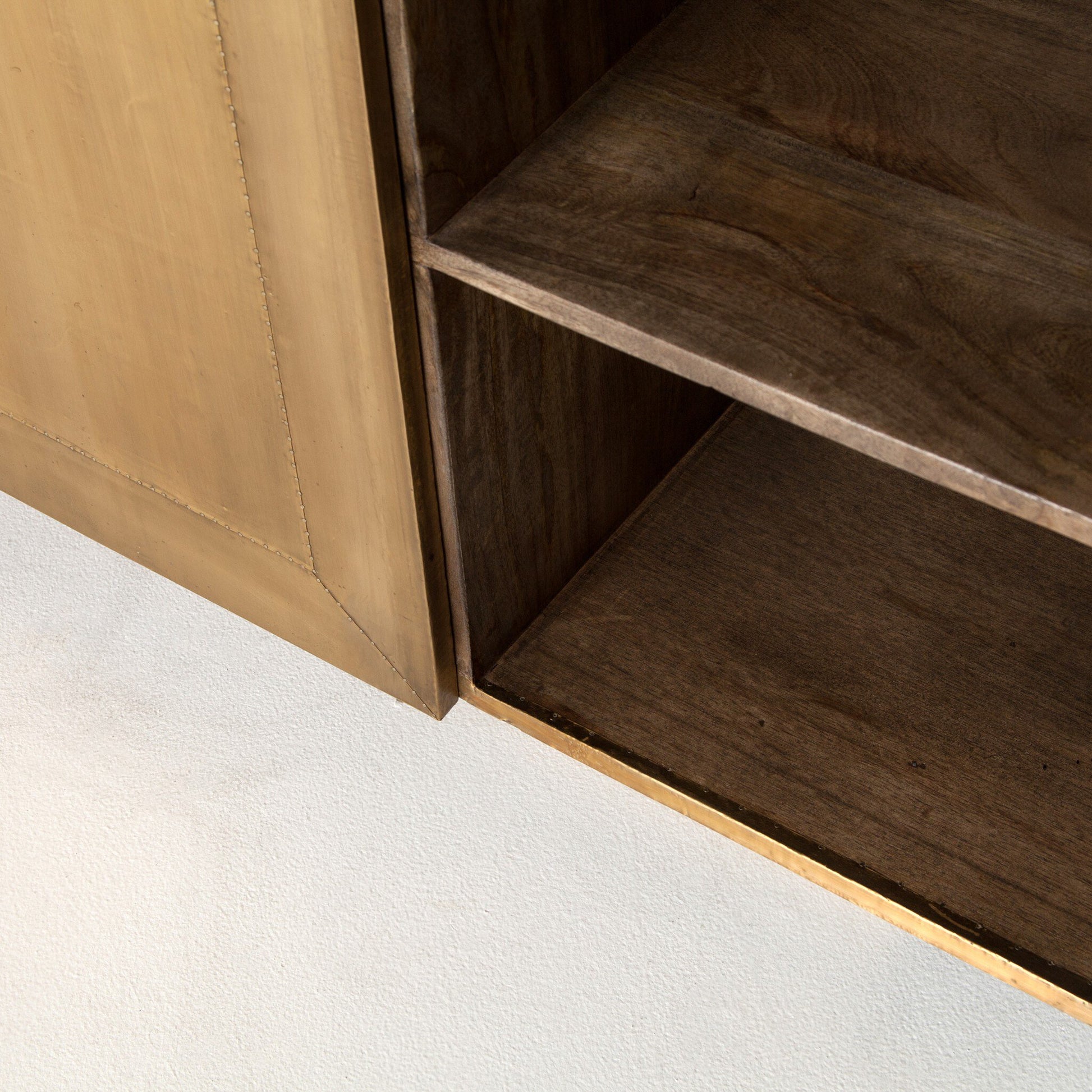 Close-up of the Brushed Brass Sideboard with an open door, revealing two empty dark wooden shelves inside. The 72"W piece has a lighter mango veneer exterior and stands on a light-colored floor.