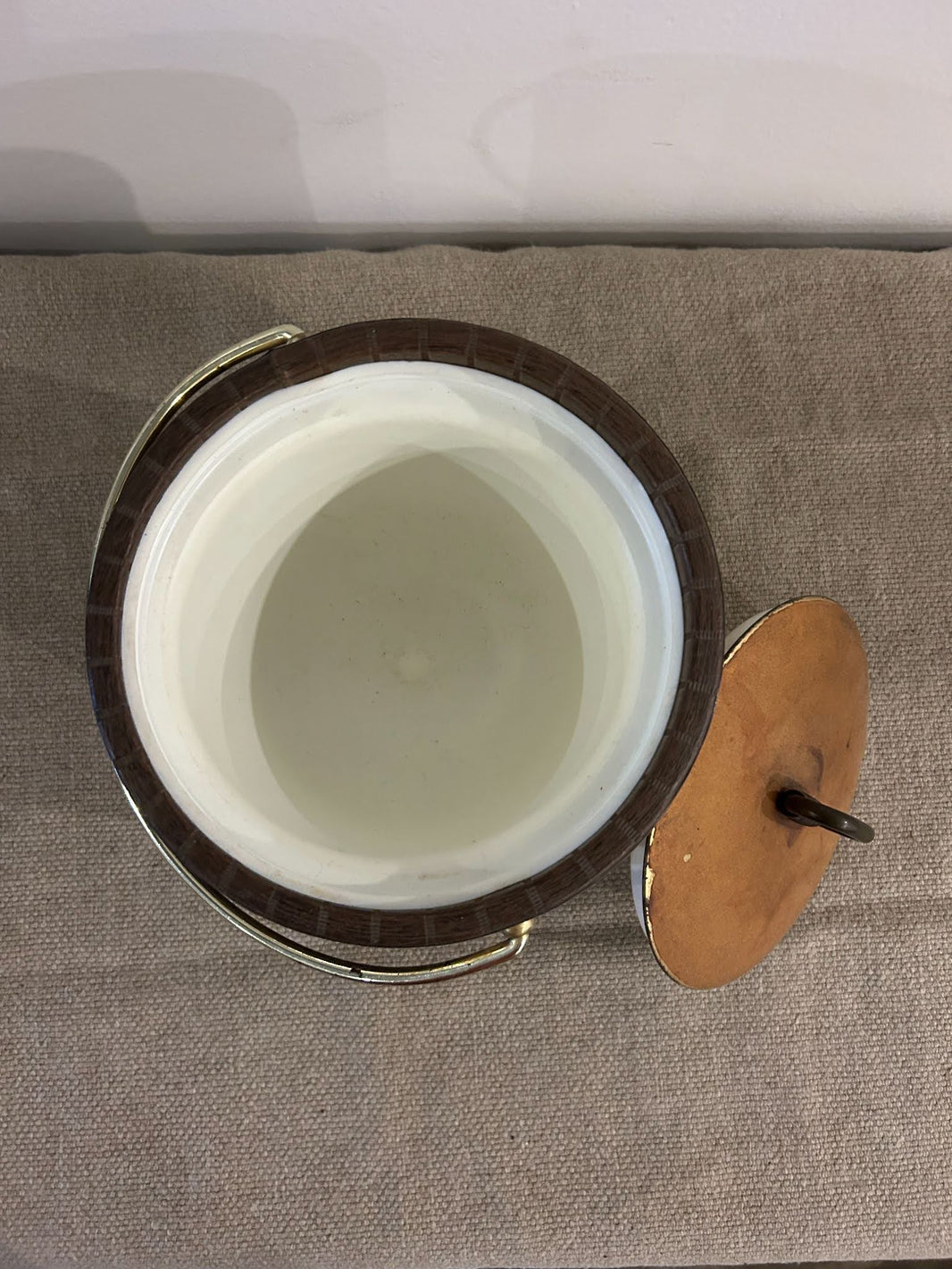 A top-down view of the 8.8-inch Ice Bucket with a brown ceramic exterior and handle, sitting on a textured beige surface. The matching brown lid is off and placed next to the container.