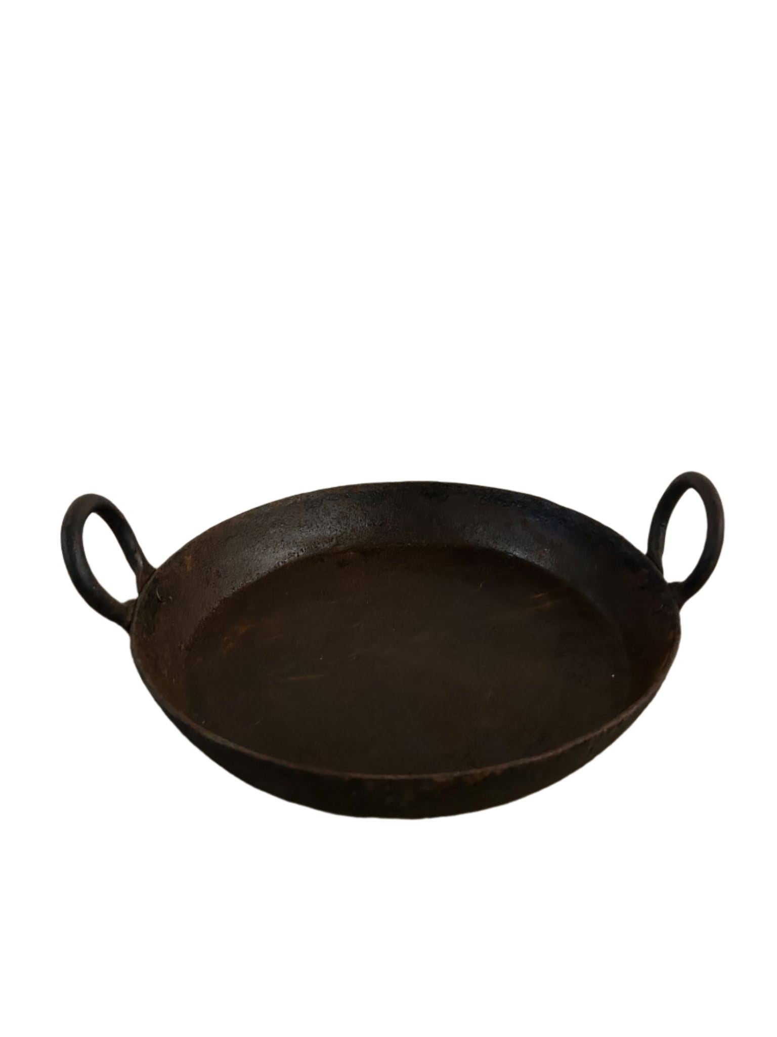 The Iron Skillet with Handles is a round, flat, black iron pan featuring two loop handles on opposite sides and measures 12"-15" wide, shown against a white background.