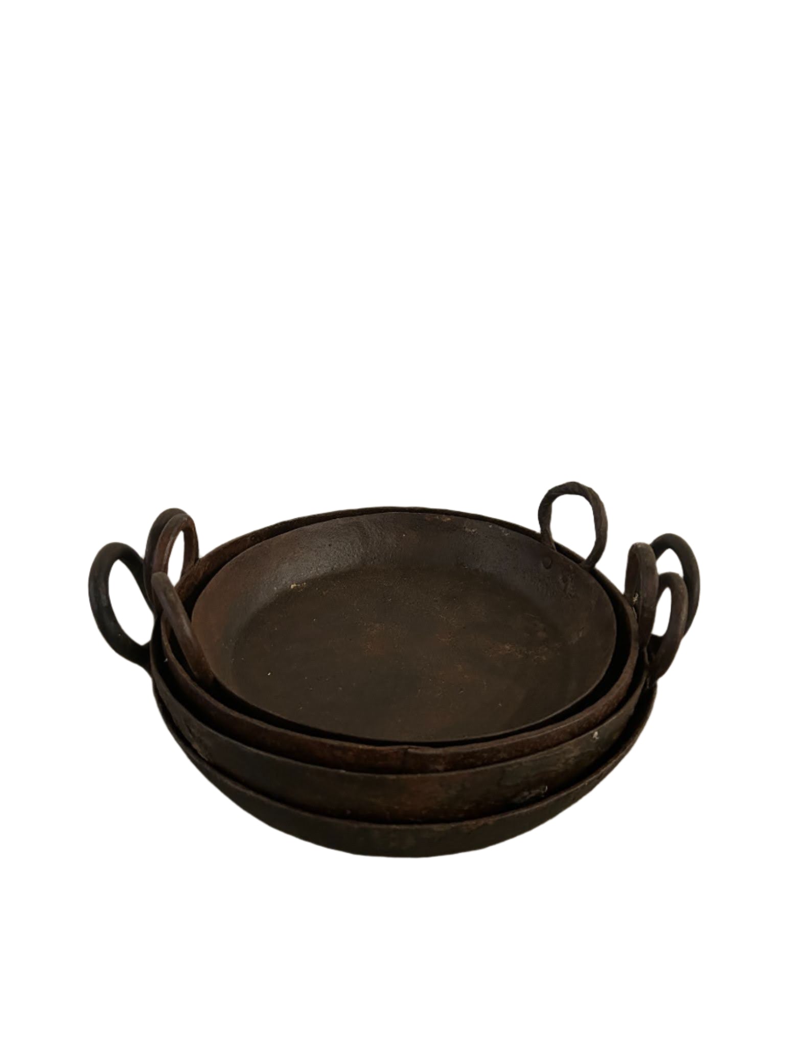 Three stacked Iron Skillets with handles on each side rest against a white background. These rustic, dark pans show signs of use and age and feature 12"-15" widths, making them versatile for various cooking needs.