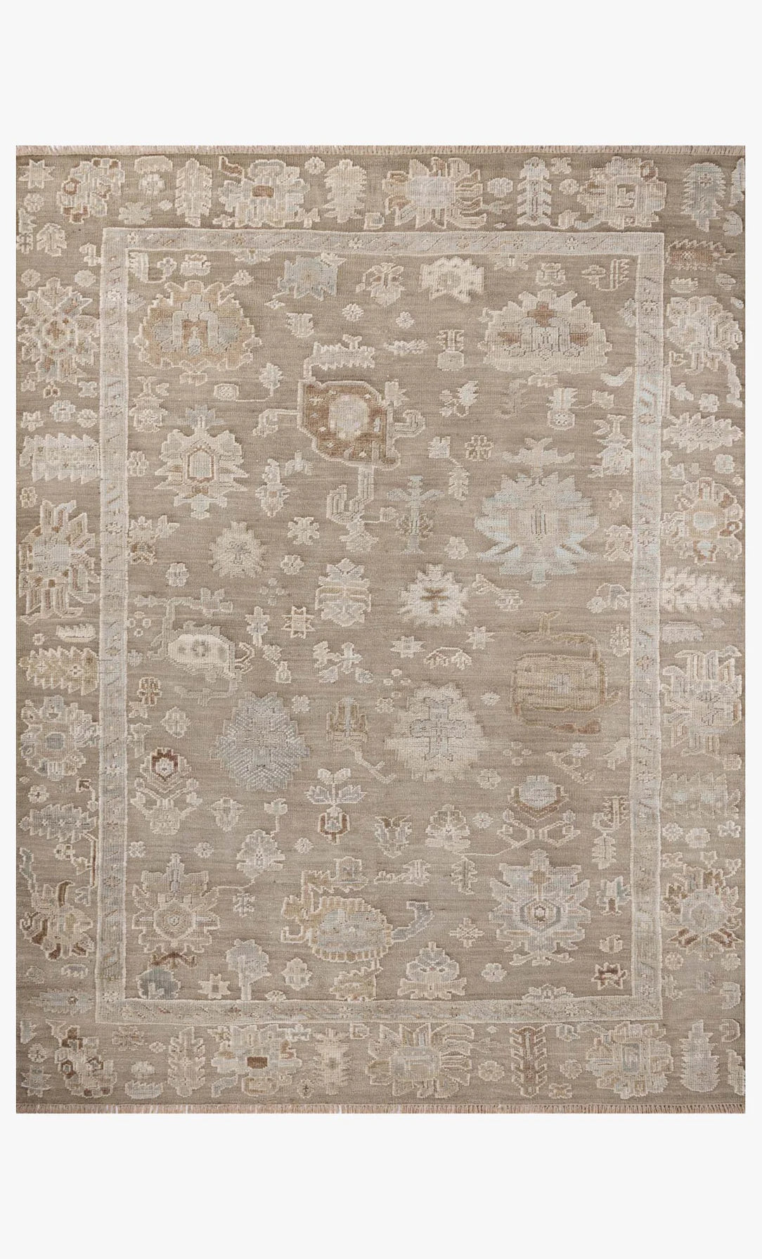The Pebble Rug 8'-6" x 11'-6" is a rectangular beige area rug made of cotton and wool, with a subtle border and abstract floral patterns in light cream, taupe, and gray.
