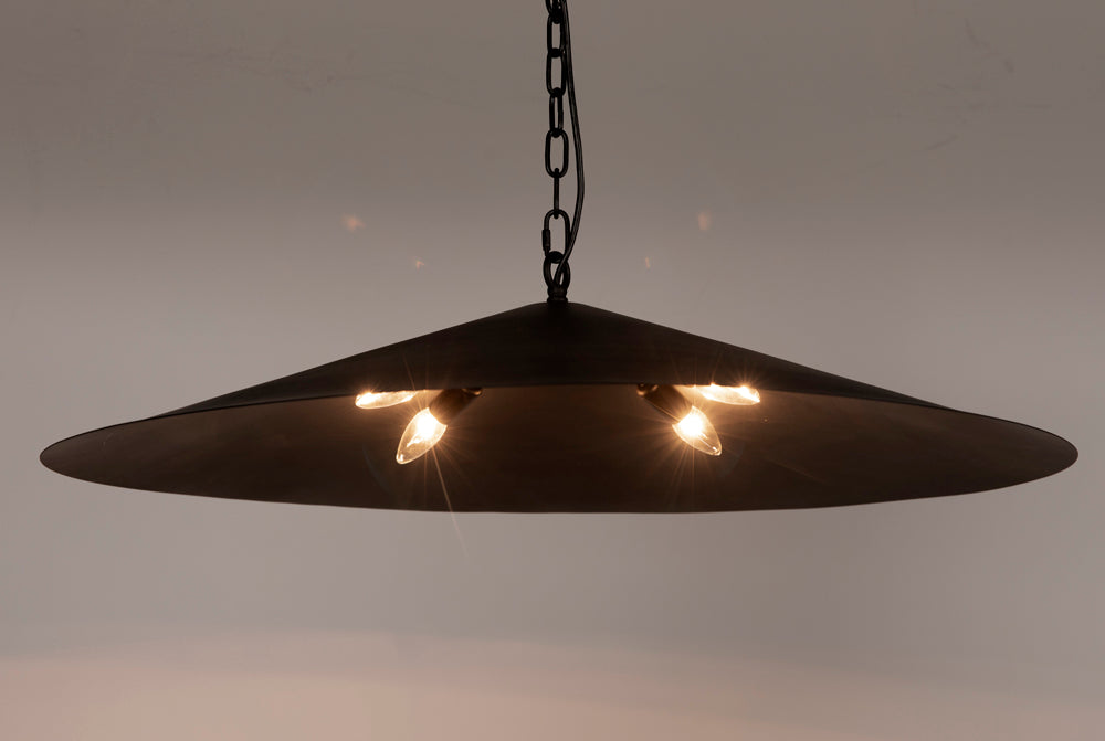 The Matte Black Industrial Pendant features a wide, cone-shaped design with exposed bulbs hanging from a chain, providing warm, downward light as both a stylish accent and functional lighting source.