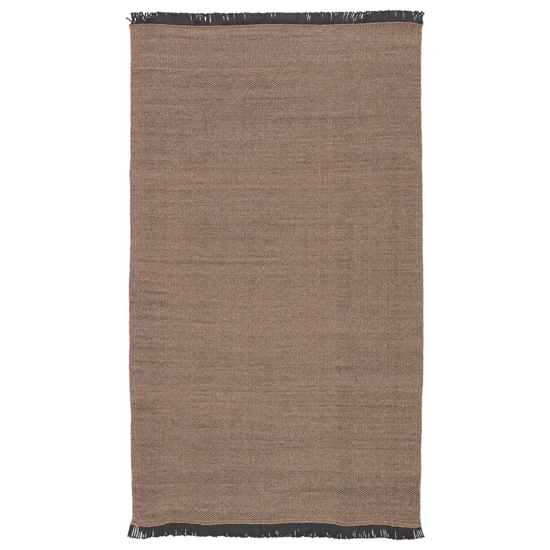 The Handcrafted Taupe Rug is a rectangular 5'x8' woven piece with a minimalist design, subtle texture, and short black fringe on the top and bottom edges.