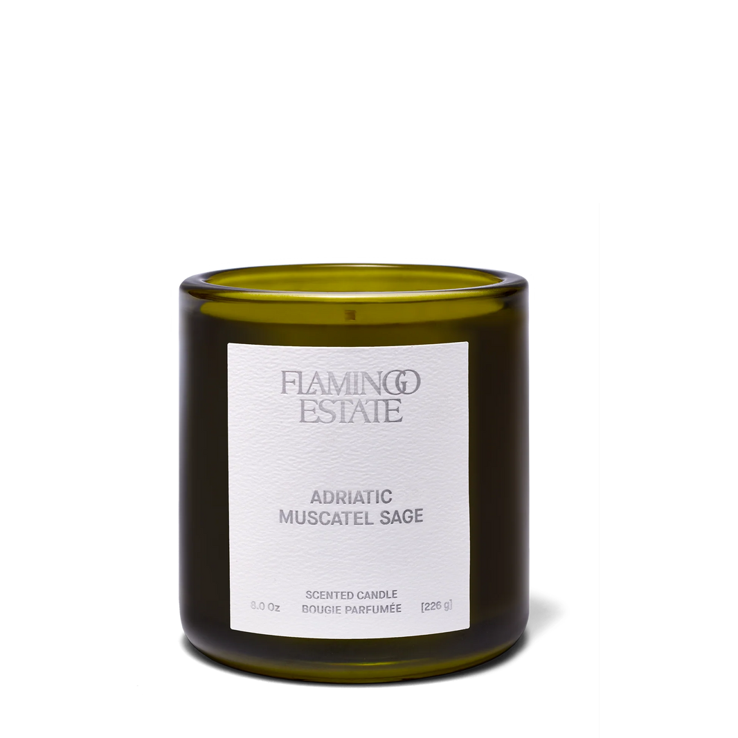 A green glass Flamingo Estate -Adriatic Muscatel Sage Candle sits on a plain white background, filling the air with the herbal scent of California sage.