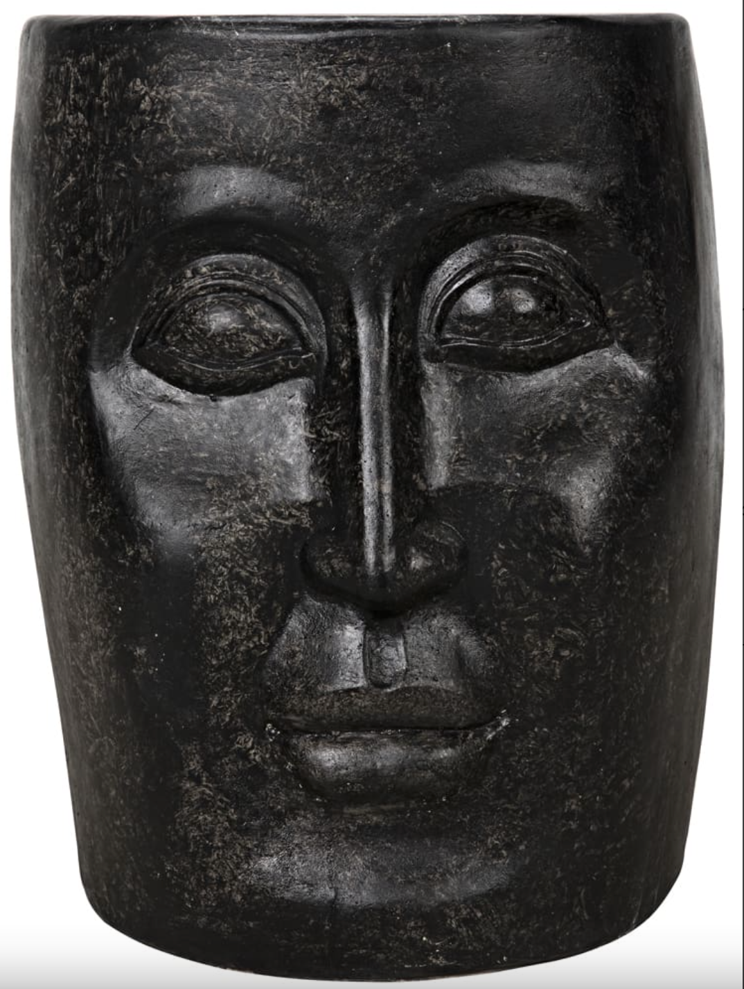 The Single-Face Stool is a dark, stone-like fiber cement accent table shaped as a human face with smooth, symmetrical features.
