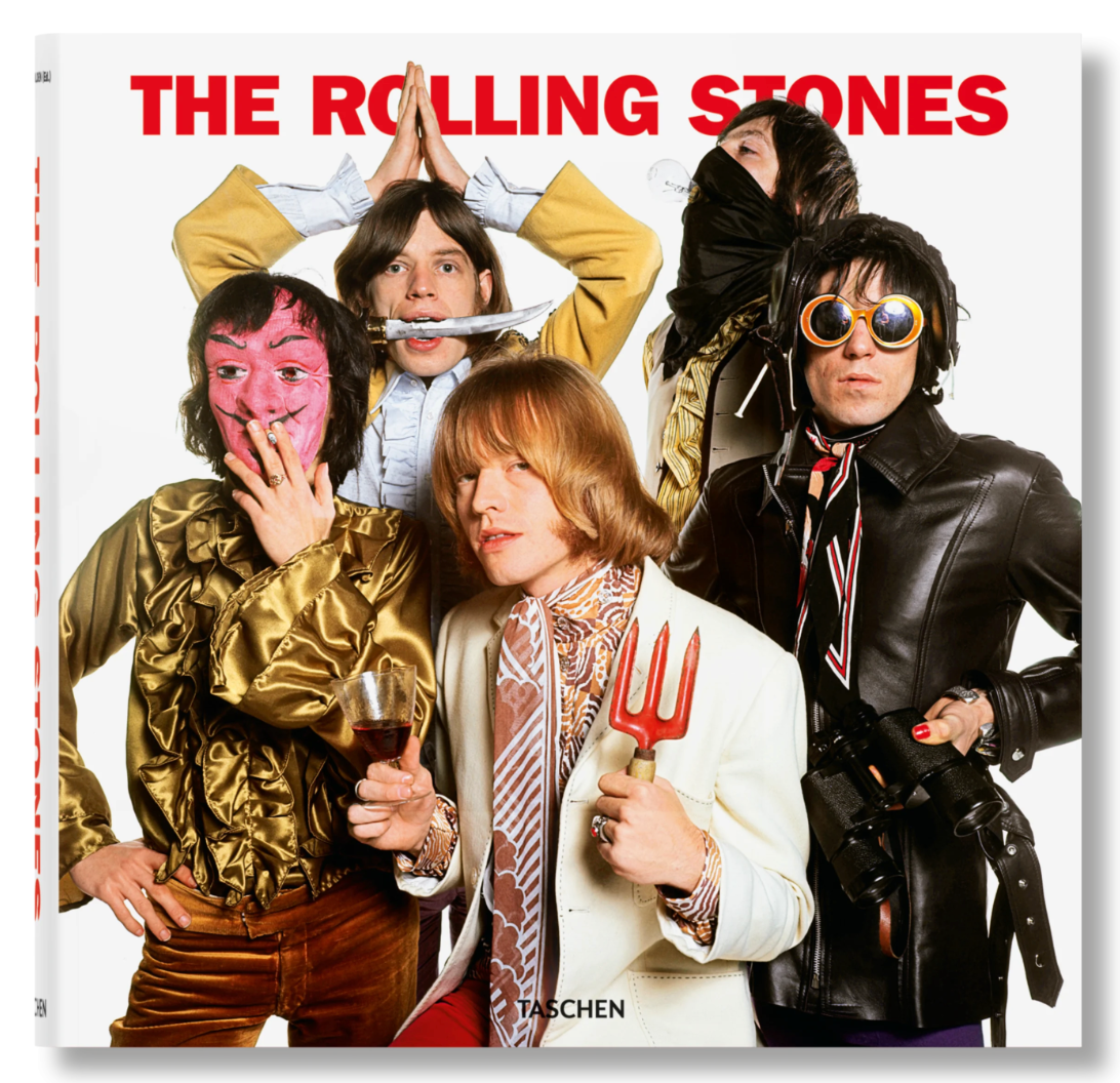 Five members of The Rolling Stones pose in vibrant costumes against a white backdrop, with the band’s name above them—a playful image featured in Rolling Stones. Updated Edition, perfect for any fan's collection.