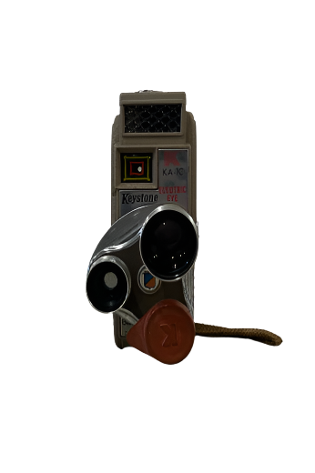 Vintage Keystone Movie Camera featuring dual lenses, a leather strap, and front labels, displayed against a white background.