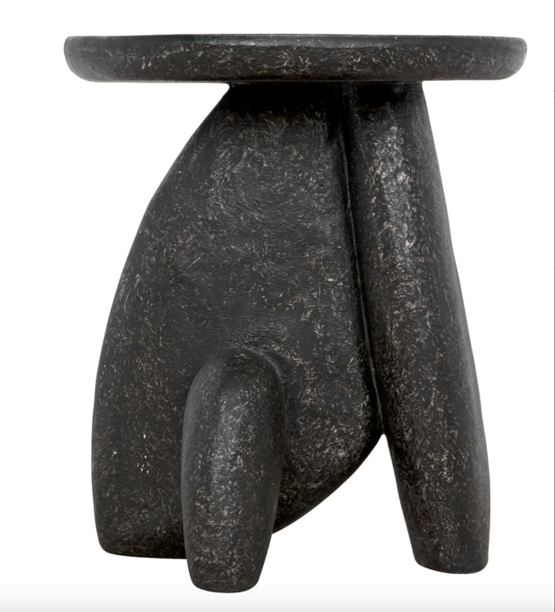The Rock Formation Side Table is a small, modern black piece with three uneven, rounded legs and a circular top. Made of fibercement, it features an abstract design with a stone-like texture and striking black stipple finish.