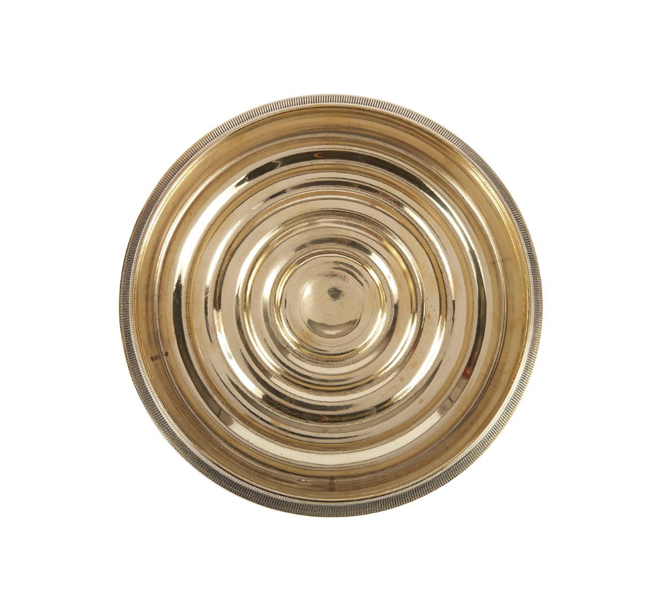 A Coin-Edged Bottle Coaster made of solid brass, featuring concentric raised circles and a 6-inch diameter, viewed from above on a white background.