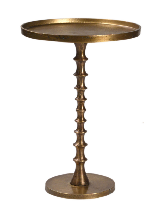 The Vintage Side Table is a small, round, aluminum piece with a gold finish. It features a flat top and a sculpted, ridged pedestal base inspired by antique brass designs for a vintage look.