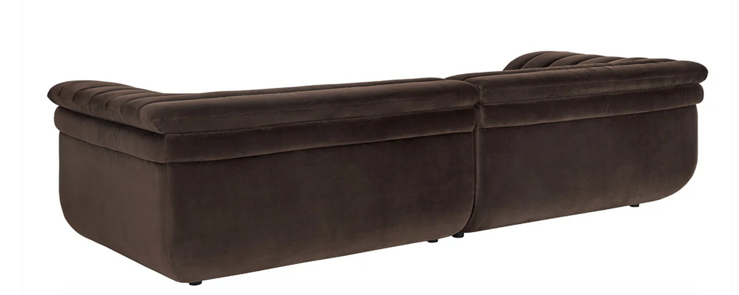 The Low-slung sculptural sofa features dark brown diamond mink upholstery with plush cushions and modern, rounded edges, shown from the back against a white background.