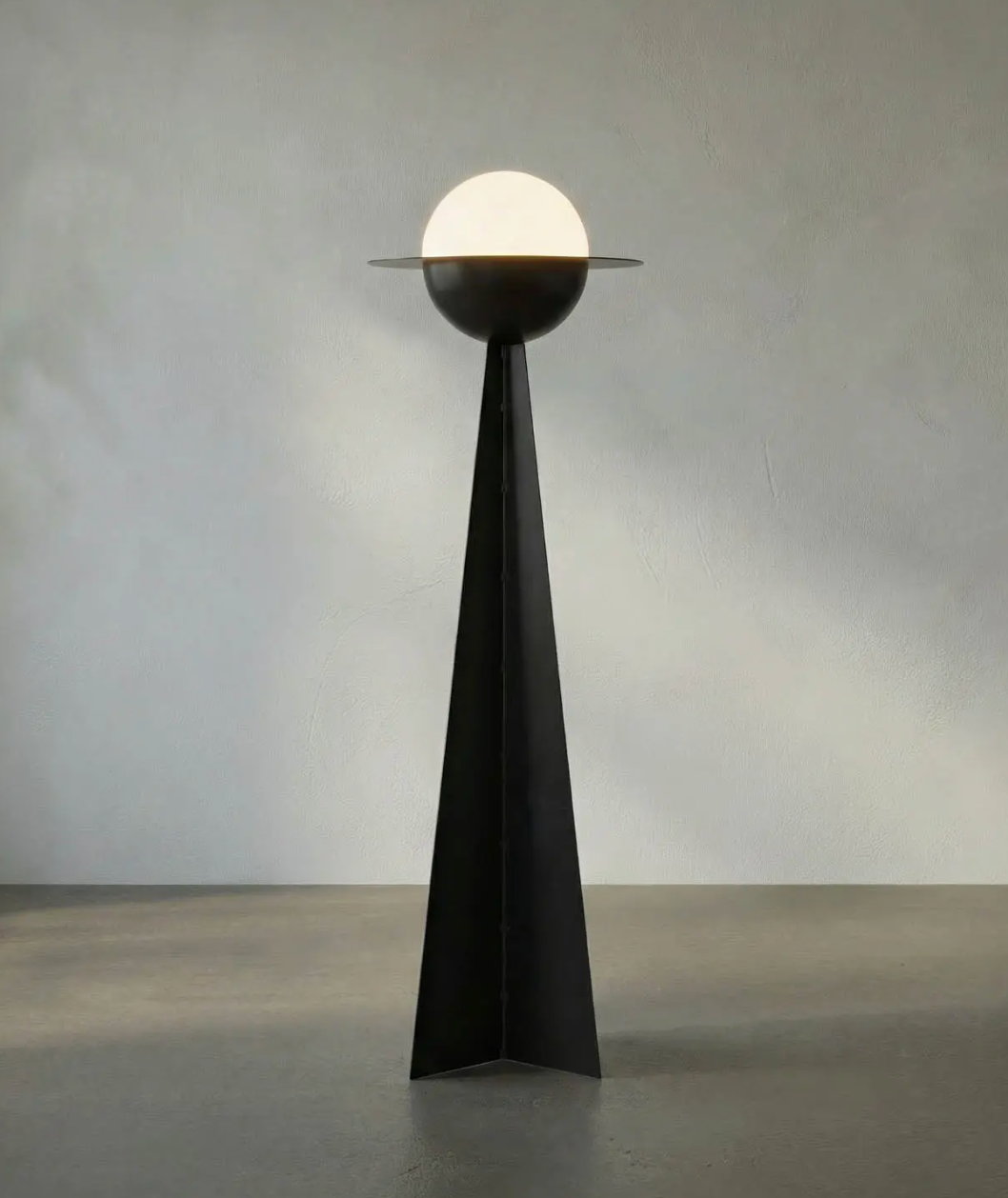 Globe Floor Lamp featuring a tall, triangular black base and a spherical frosted glass shade encircled by a thin flat disc.