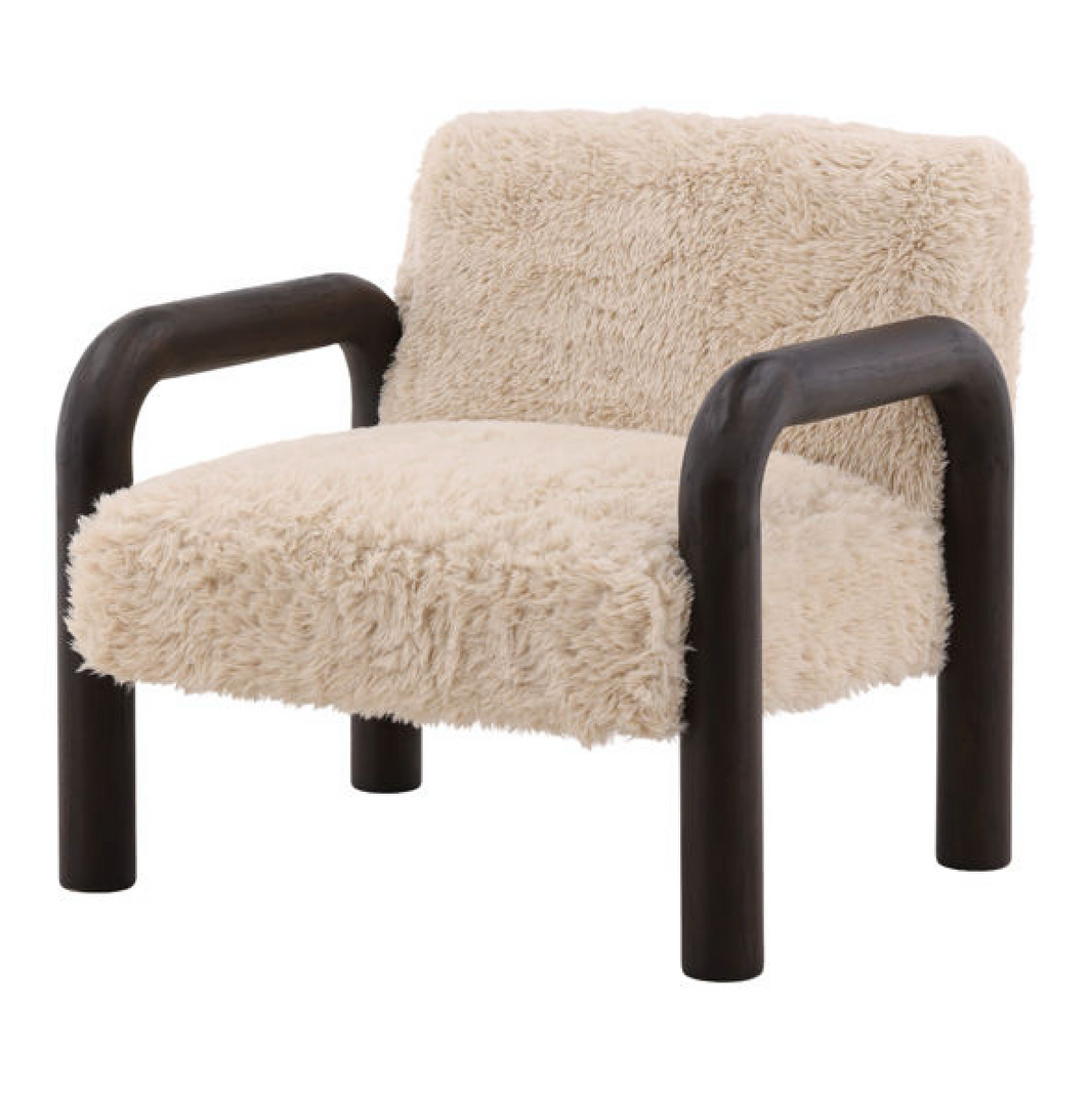 The Fur Armchair with Curved Wooden Frame features soft sand fur fabric upholstery and thick, rounded dark brown wooden arms and legs, offering a modern accent to any space.