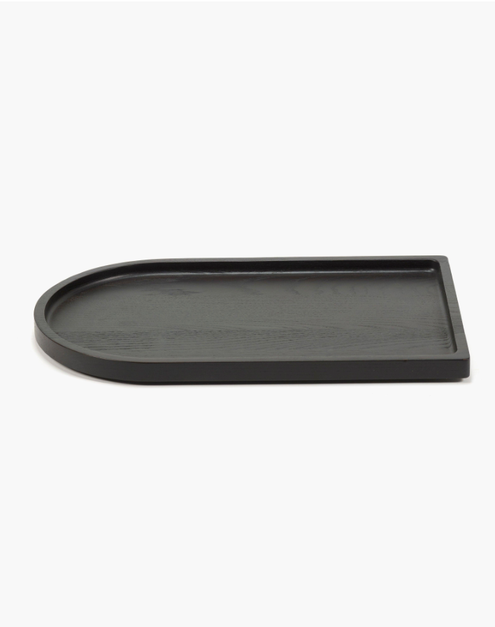 The Large Black Arch Tray is a rectangular serving tray made from carbonised ash, with one rounded end and a black finish, shown against a white background.