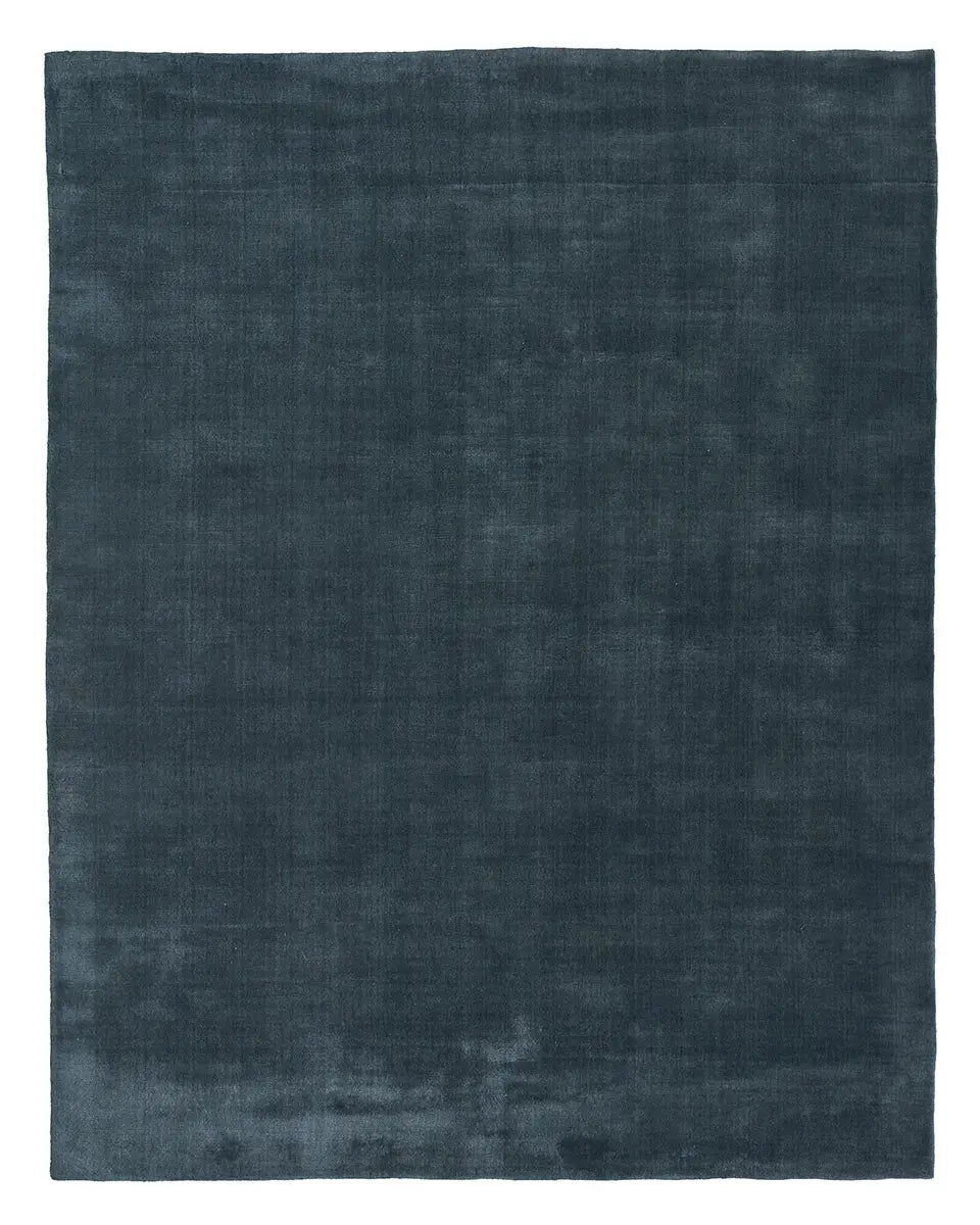 A handwoven New Zealand Wool Rug in a rectangular 8x10 size, featuring a dark blue color, soft velvety texture, and simple solid design crafted from premium wool.