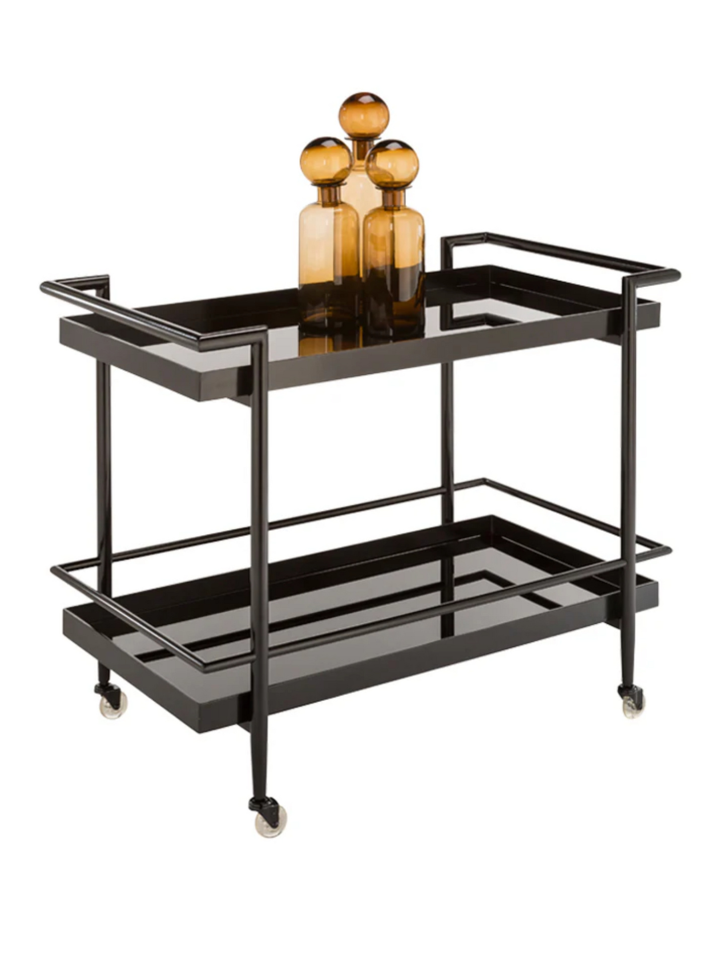 The Smoke Glass Bar Cart features sleek black metal, black glass shelving, and four wheels. On the top shelf sit three amber glass bottles of different heights.