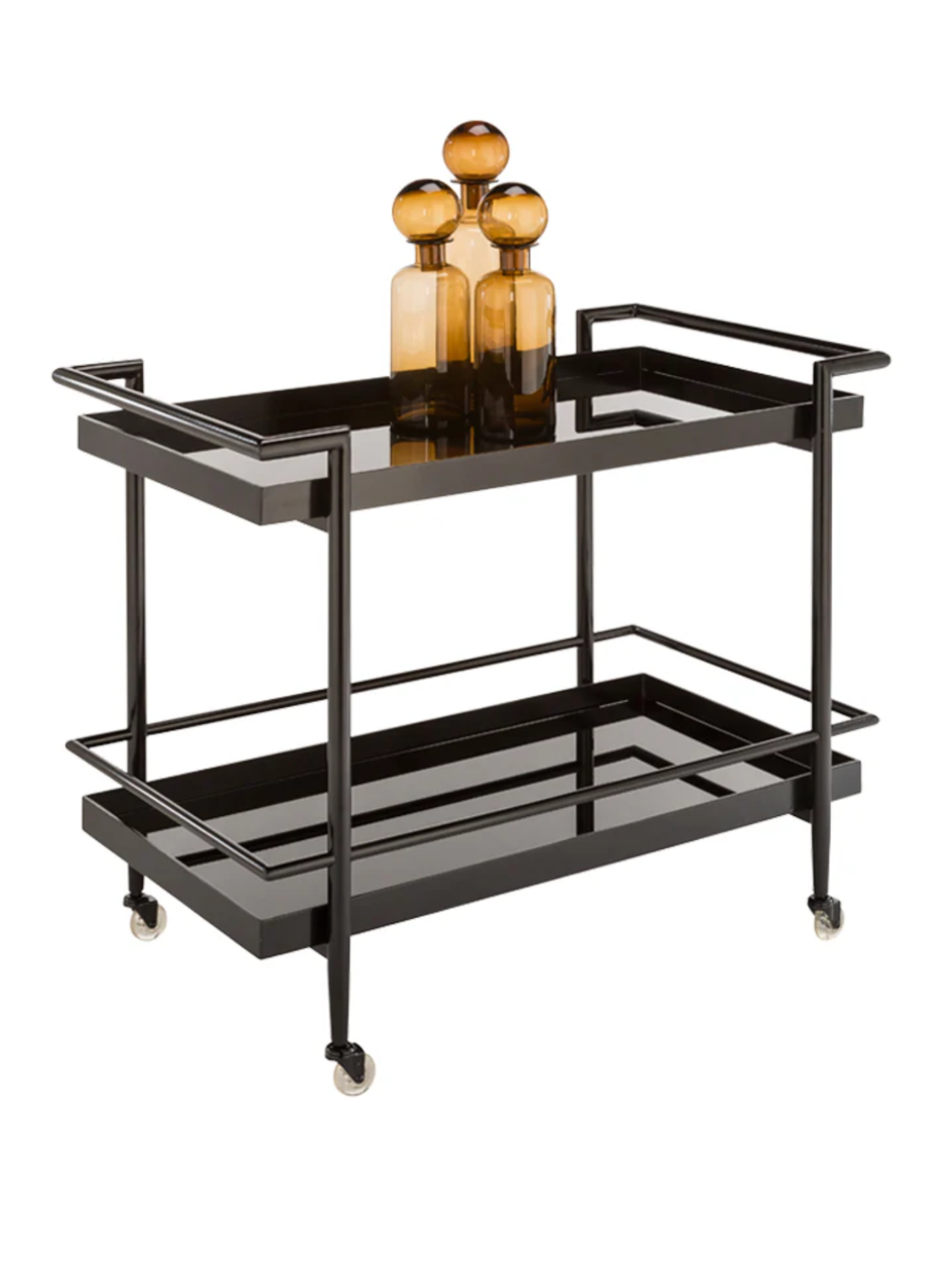 The Smoke Glass Bar Cart features sleek black metal, black glass shelving, and four wheels. On the top shelf sit three amber glass bottles of different heights.
